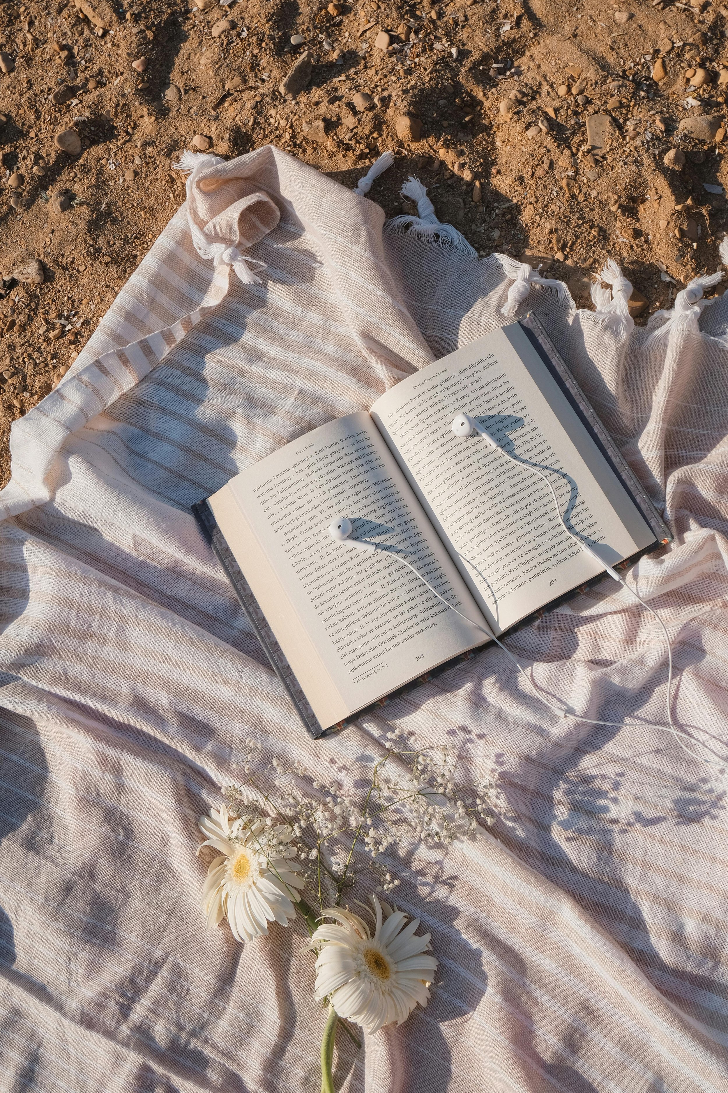 An open book and earphones on a blanket, representing the calming effects of the Safe and Sound Protocol (SSP) in Tampa and New Port Richey.