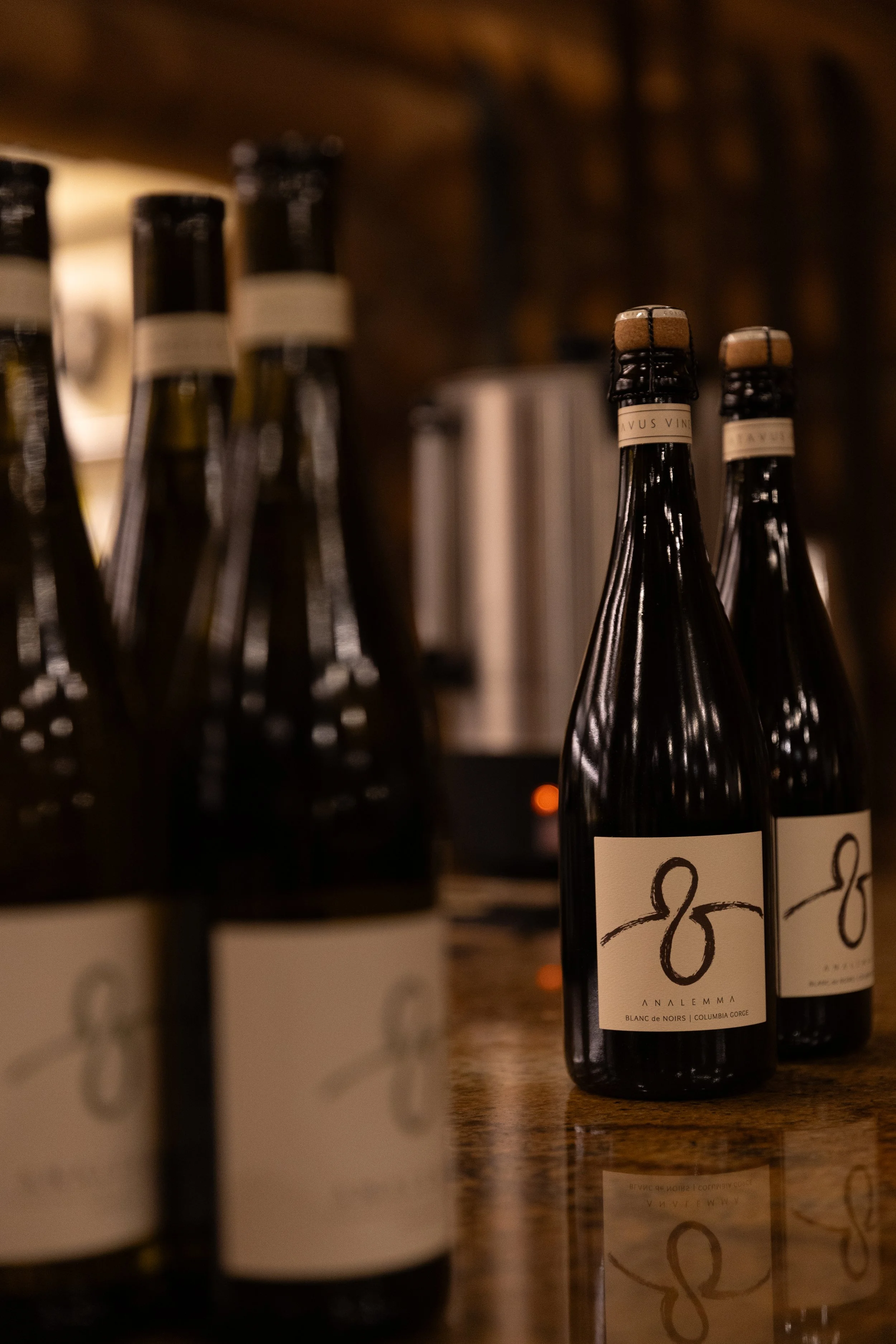 Several bottles of wine on a wooden surface with a blurred background.