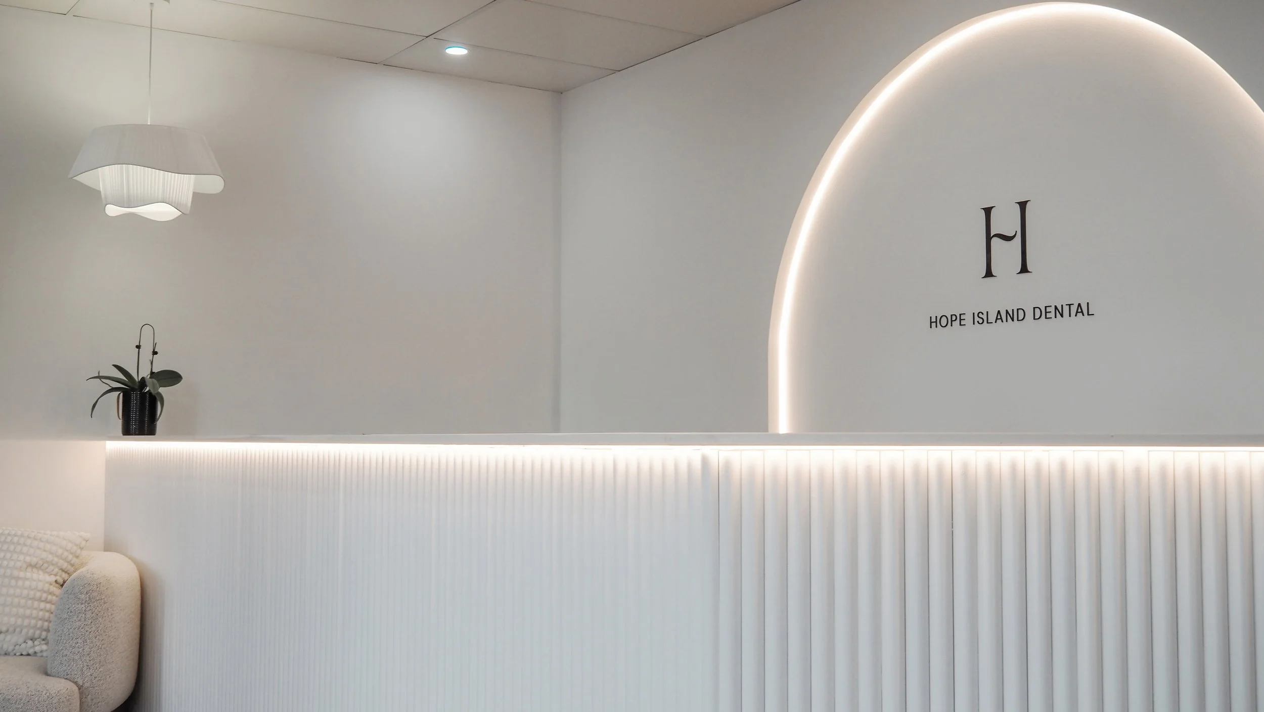 Close up of Hope Island Dental reception area with pot plant, neutral decor and LED lighting