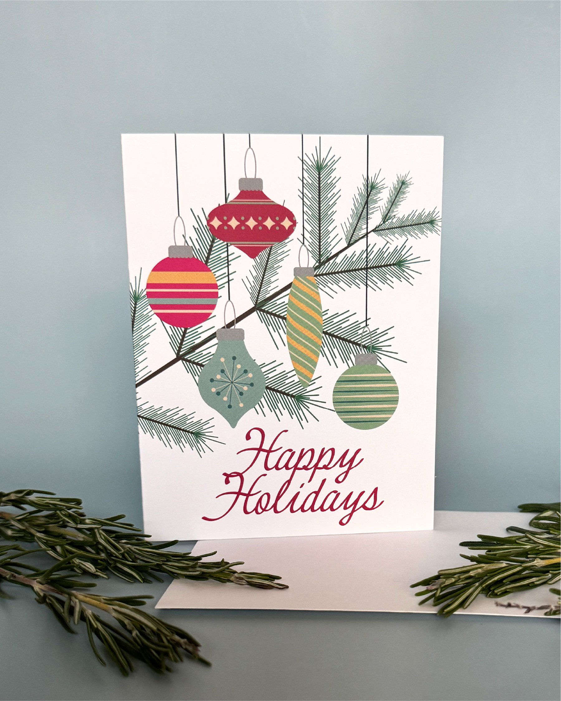 Happy Holiday greeting card with an illustrated pine brand with mid-century style ornaments
