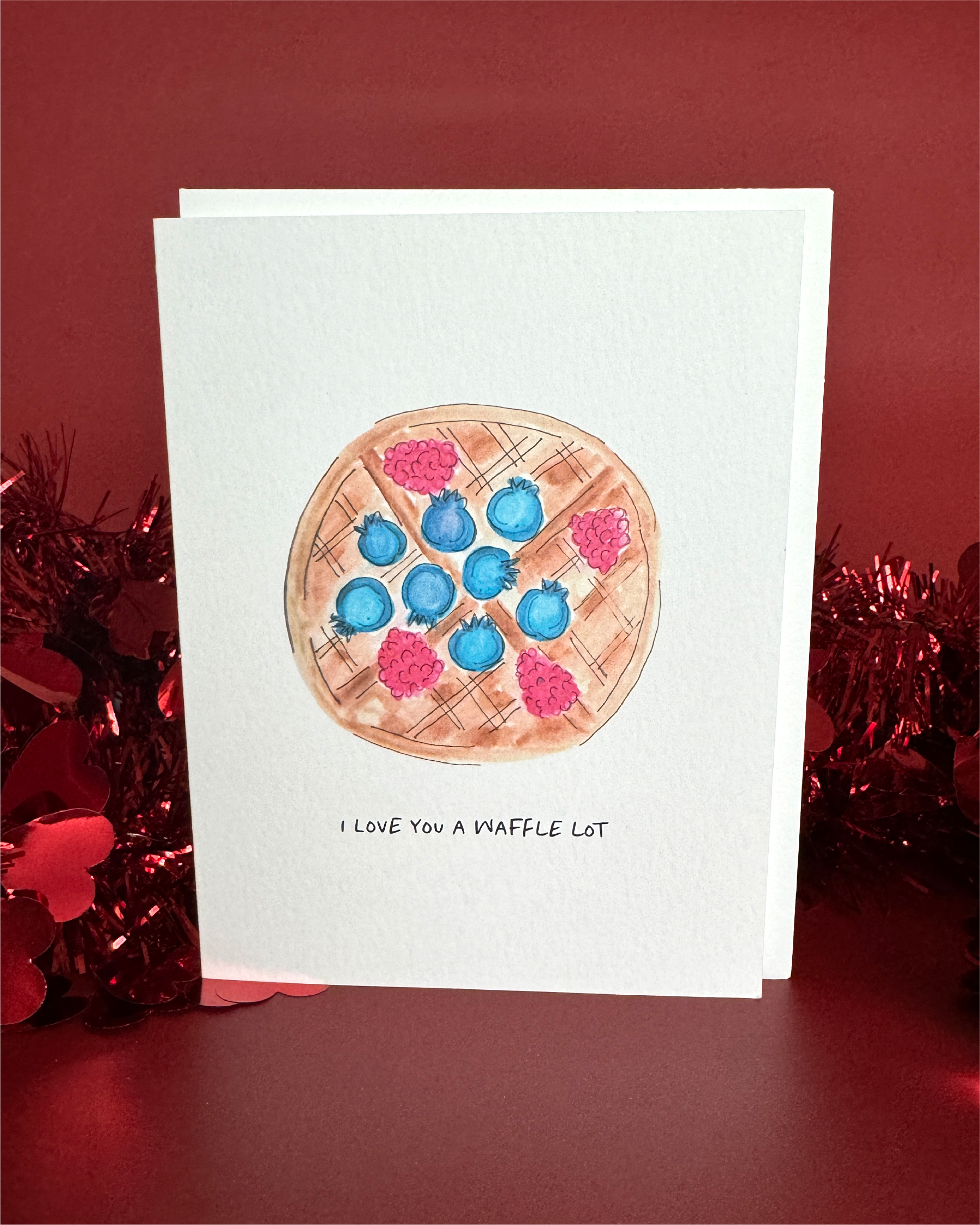 Greeting card with a watercolor waffle and fruit that reads, "I love you a waffle lot".