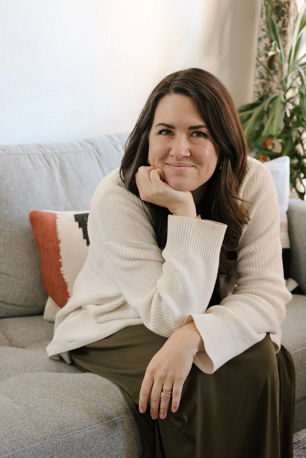Therapist on couch, smiling and ready to provide couples therapy
