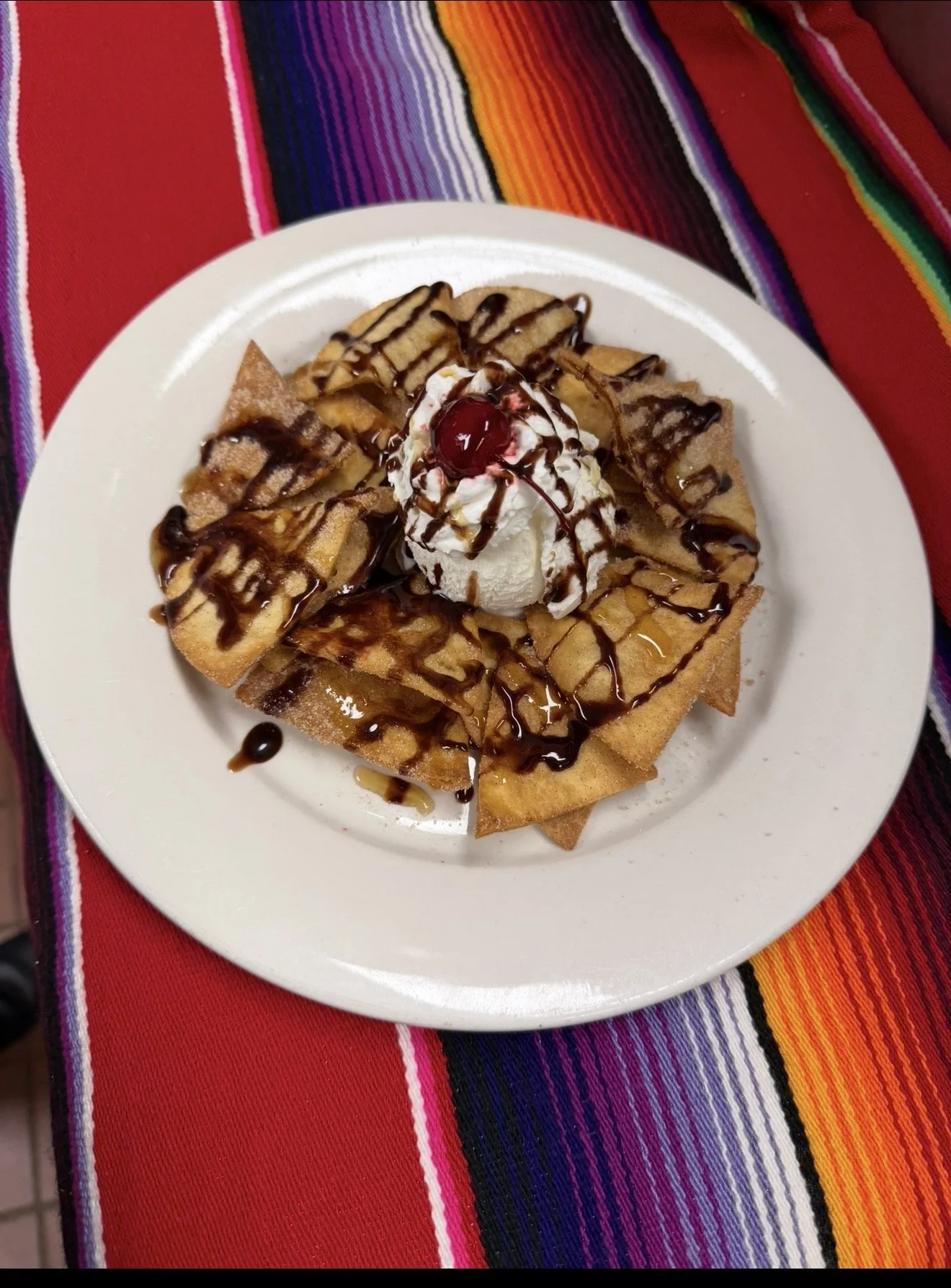 Enjoy warm, crispy sopapillas coated with cinnamon sugar and served with vanilla ice cream, whipped cream, chocolate and caramel drizzle, and a cherry. A delicious Mexican dessert at Avocado Mexican Restaurant in Bethel, Connecticut.