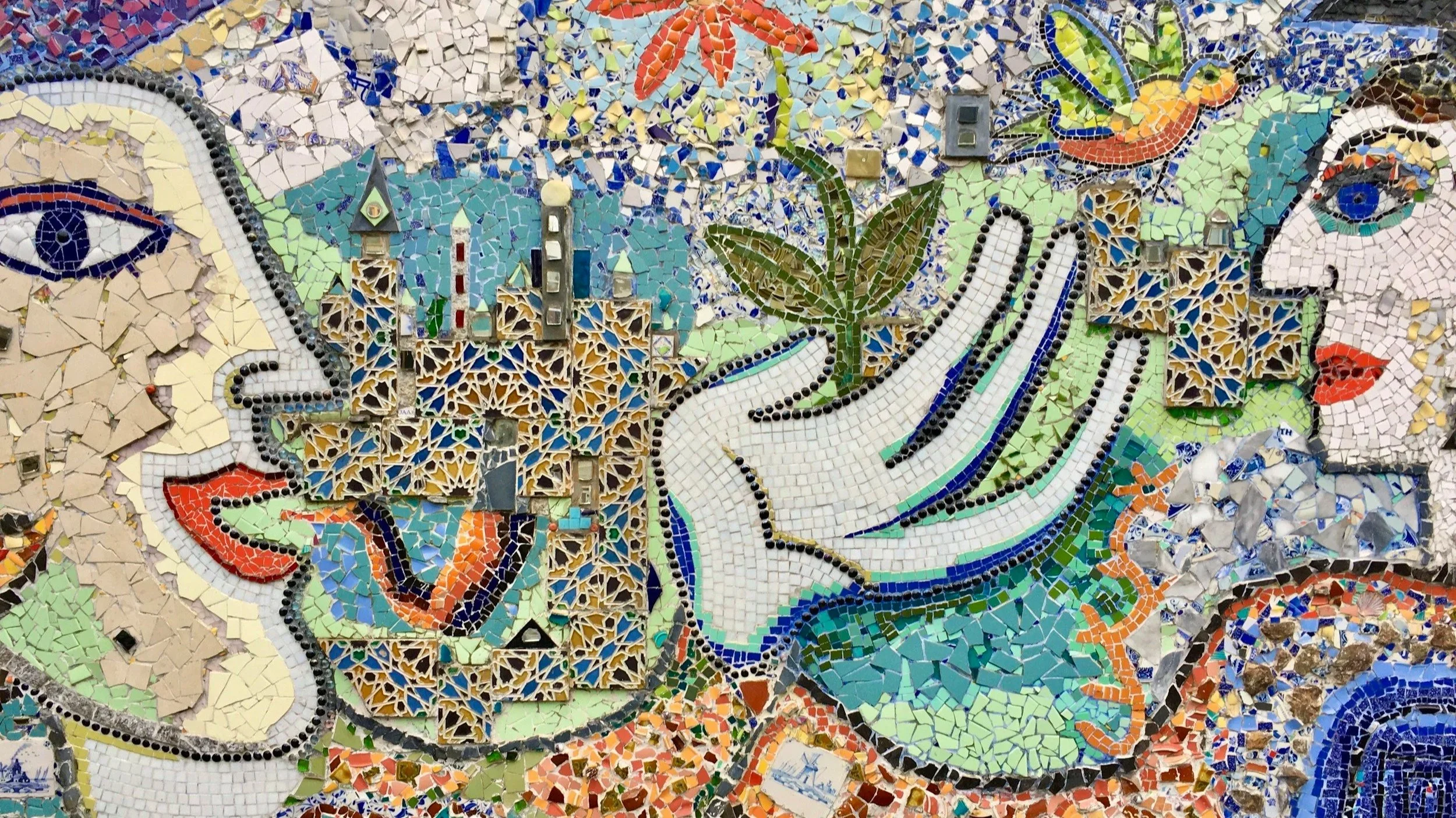 Colorful mosaic artwork showing abstract faces and expressive shapes, suggesting communication and interaction