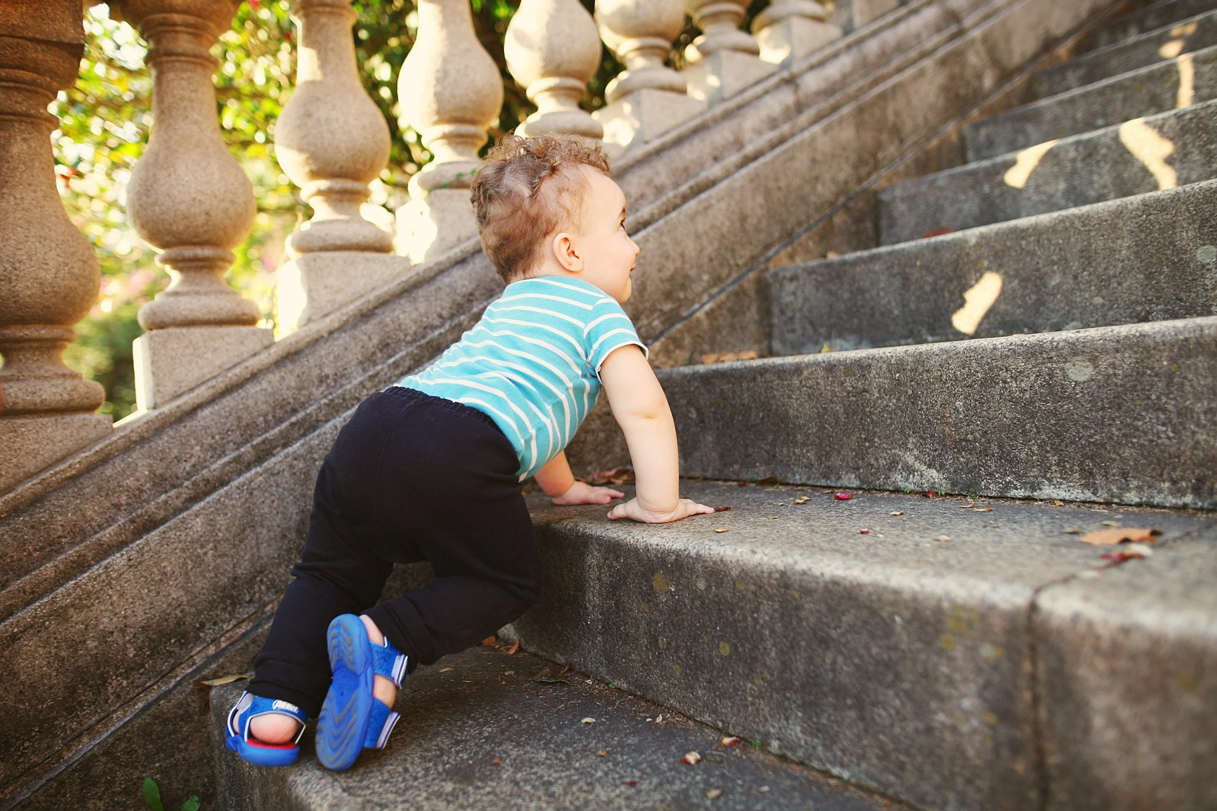 A baby walking up steps.