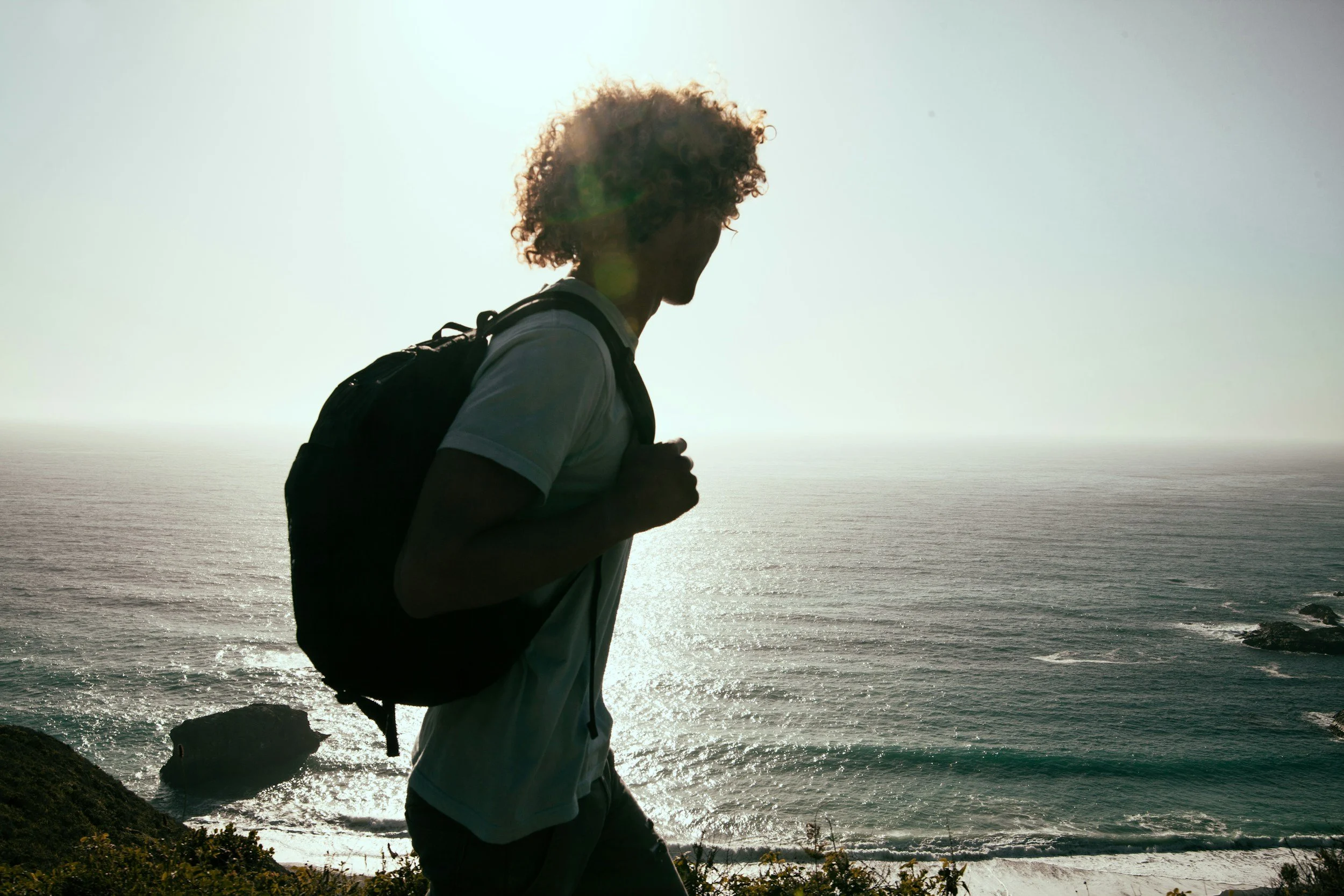 A person hiking along a coastal cliff at sunset, representing the idea that dating is an ongoing process of exploration.