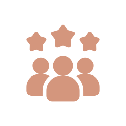 Modern wooden building with large front window set in a mountainous landscape, with two people visible inside through the window.