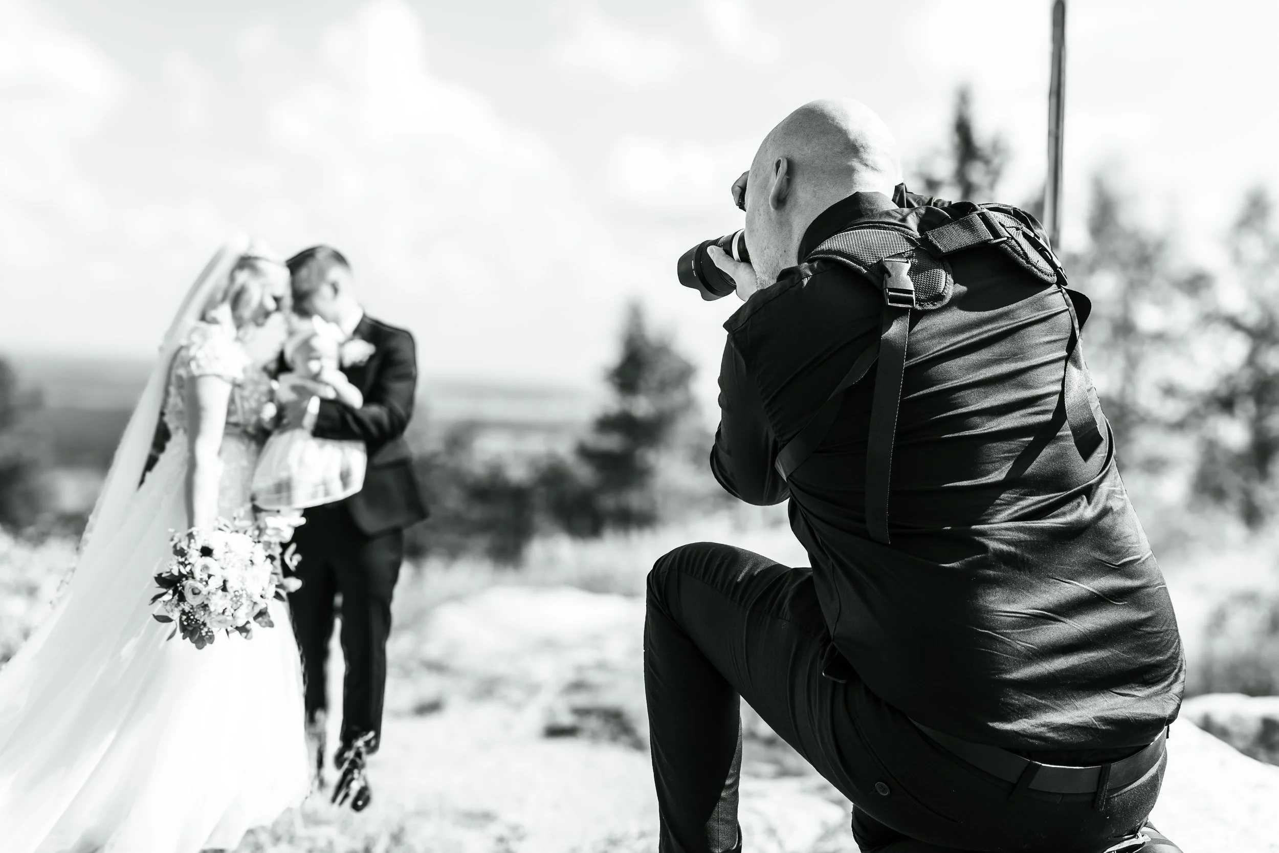 Nikals Pehkonen eli NikkeVisuals ottaa kuvia häistä, joissa morsian ja sulhanen suutelevat, ulkona luonnossa.