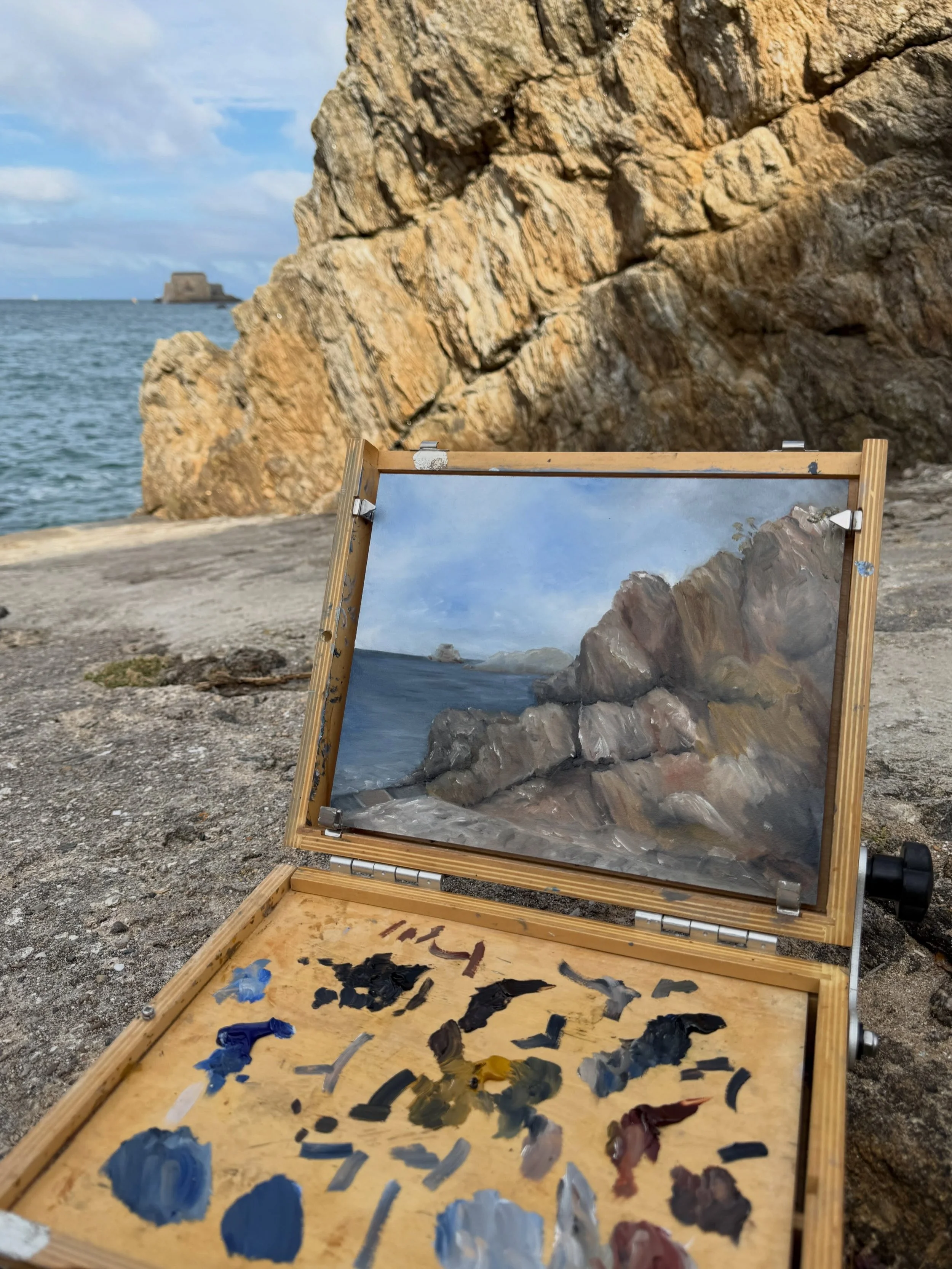 The painting began with where I chose to stand.

I came here for this opening between the rocks.

From this exact point, the rock takes over almost half the view, the sea slips behind it, and the fort becomes very small in the distance.

So that beca