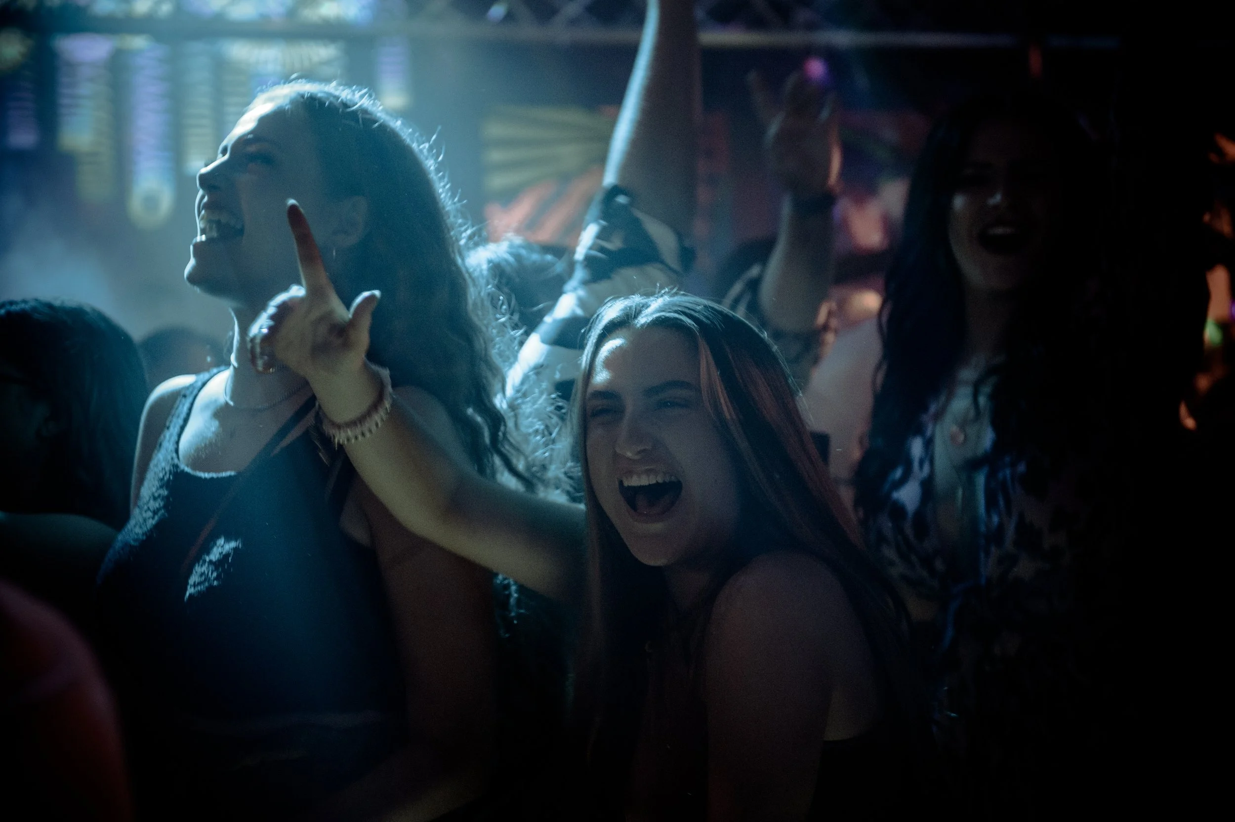 People dancing and cheering at a nightclub.