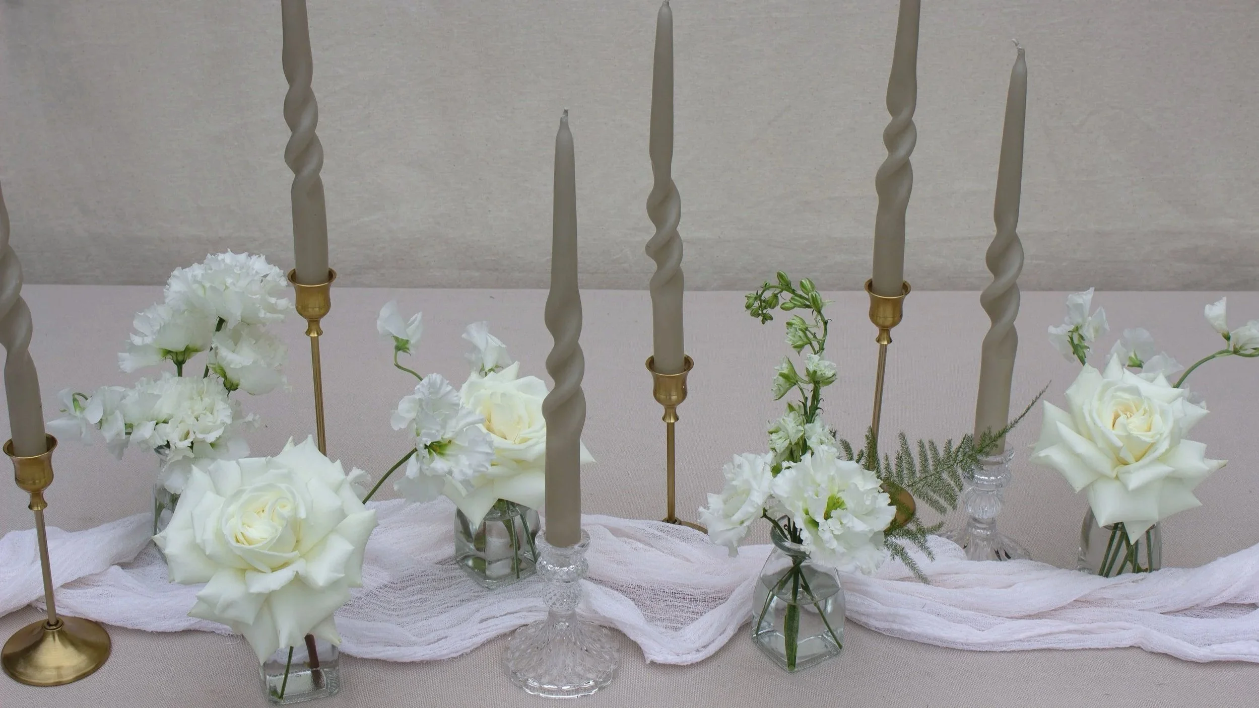 white wedding flowers, tablescape with white lisianthus, sweet peas, roses, lisianthus and taper candles in gold candlesticks
