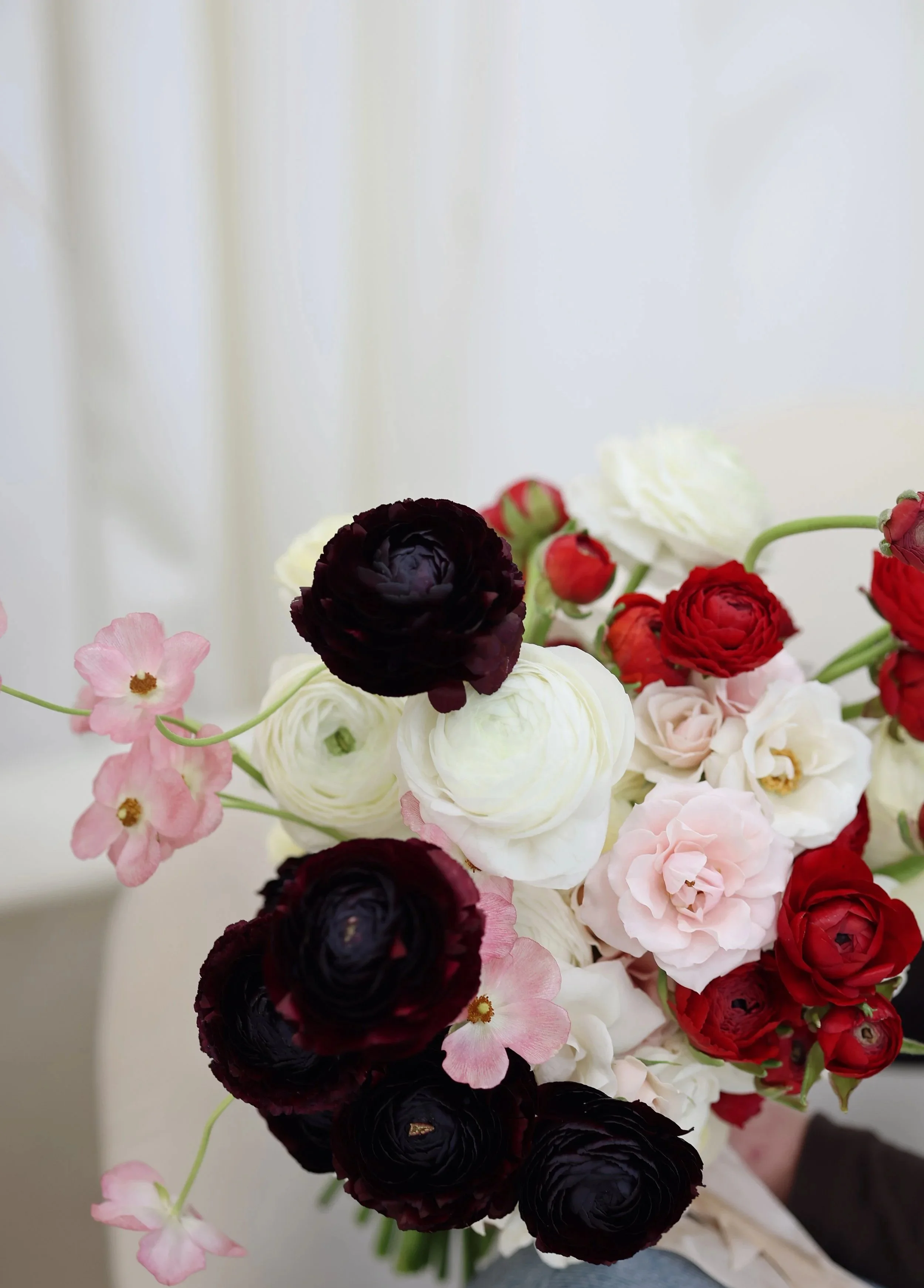 Spring Bridal Bouquet in burgundy, red, pink and cream tones, including ranunculus and roses