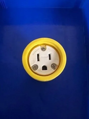Electrical outlet socket on a blue surface with a yellow border