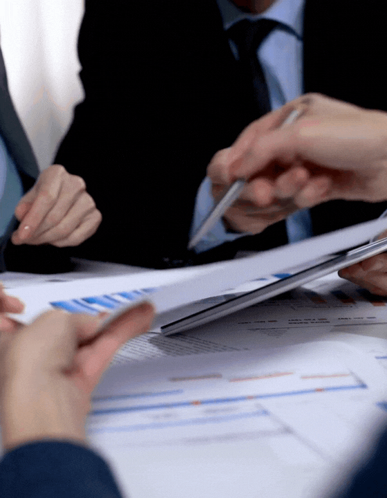 Business meeting with hands pointing at charts