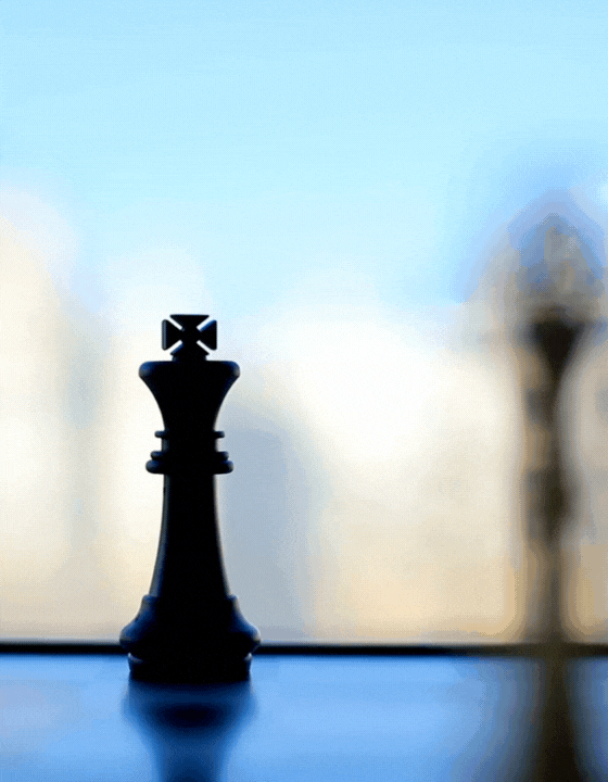 Silhouette of a chess king piece on a reflective surface with a blurred background.