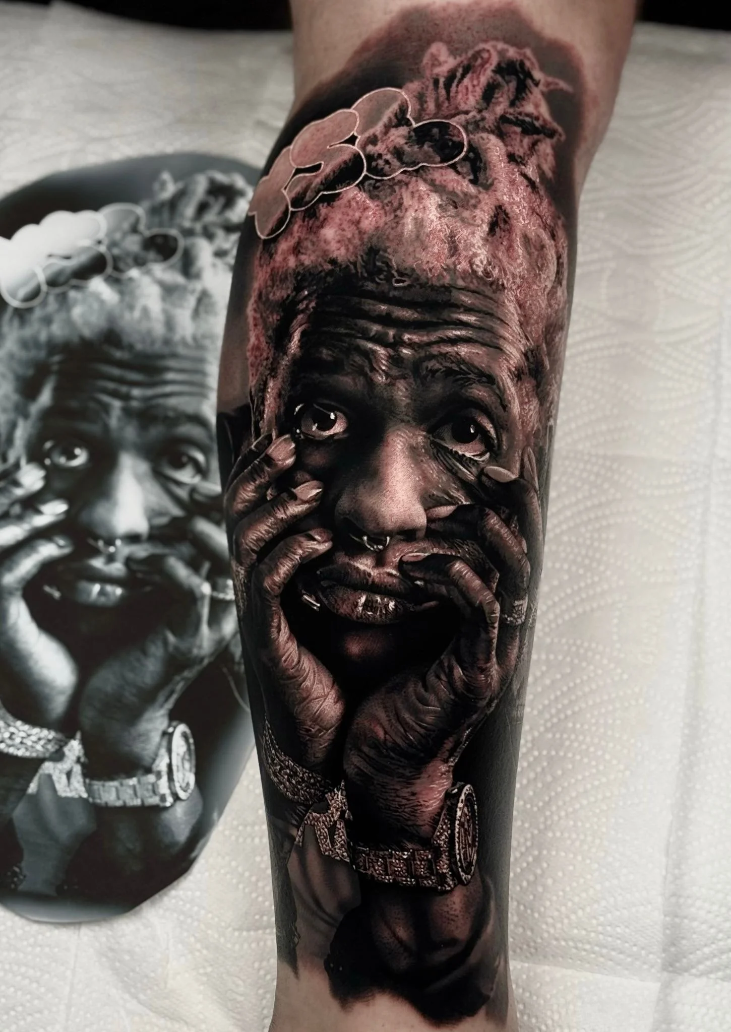 Tattoo of a realistic black woman with hands on face, showing detailed facial features and jewelry