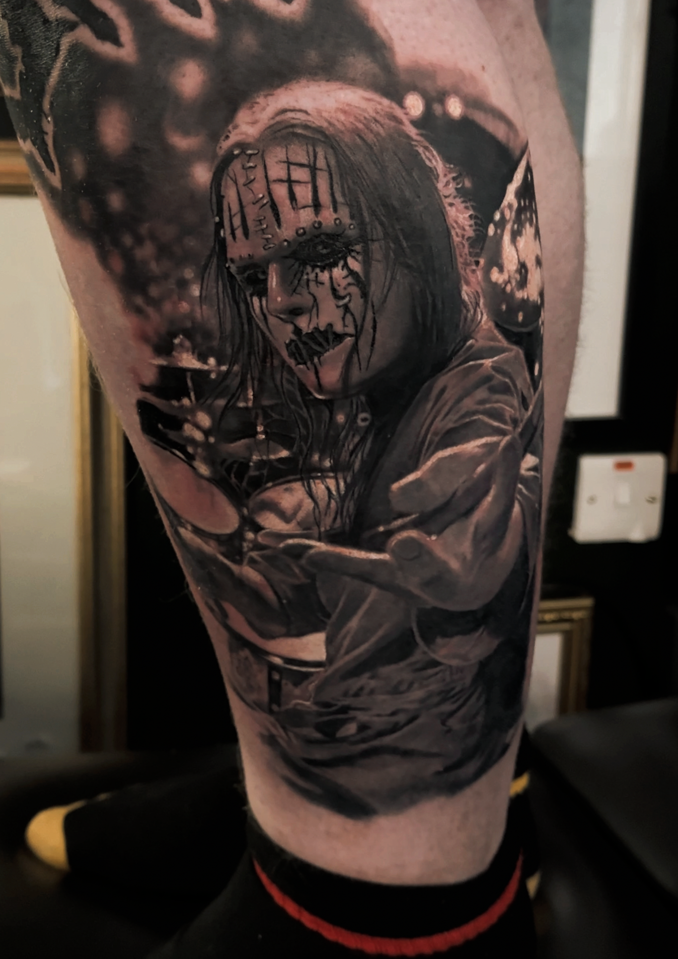 Tattoo of a woman with face paint, long hair, and a dark background.