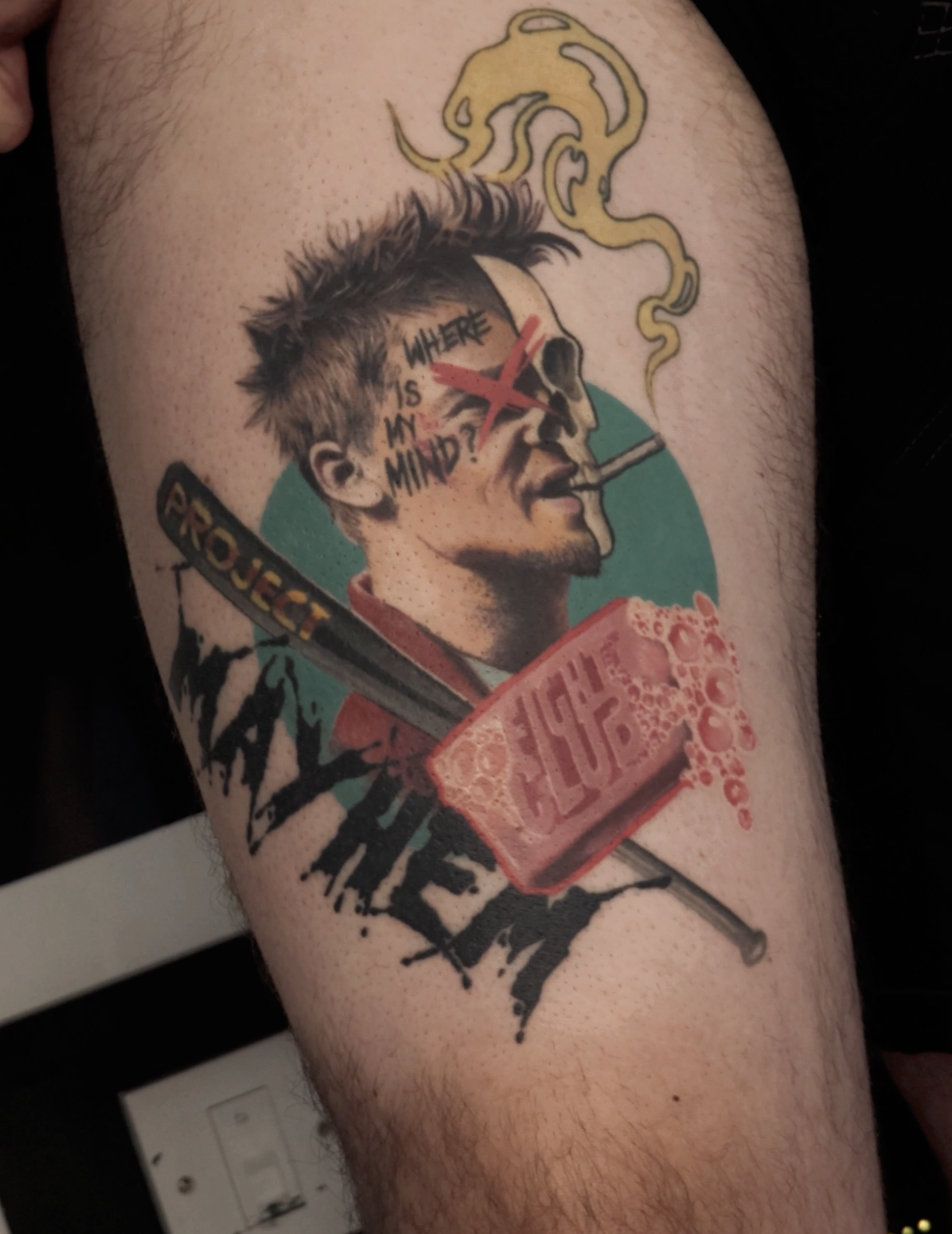 Tattoo of a man with a cigarette, a skull, and a soap bar with bubbles, featuring the text "WHERE IS MY MIND?" and a baseball bat with the word "PROJUE" on it.