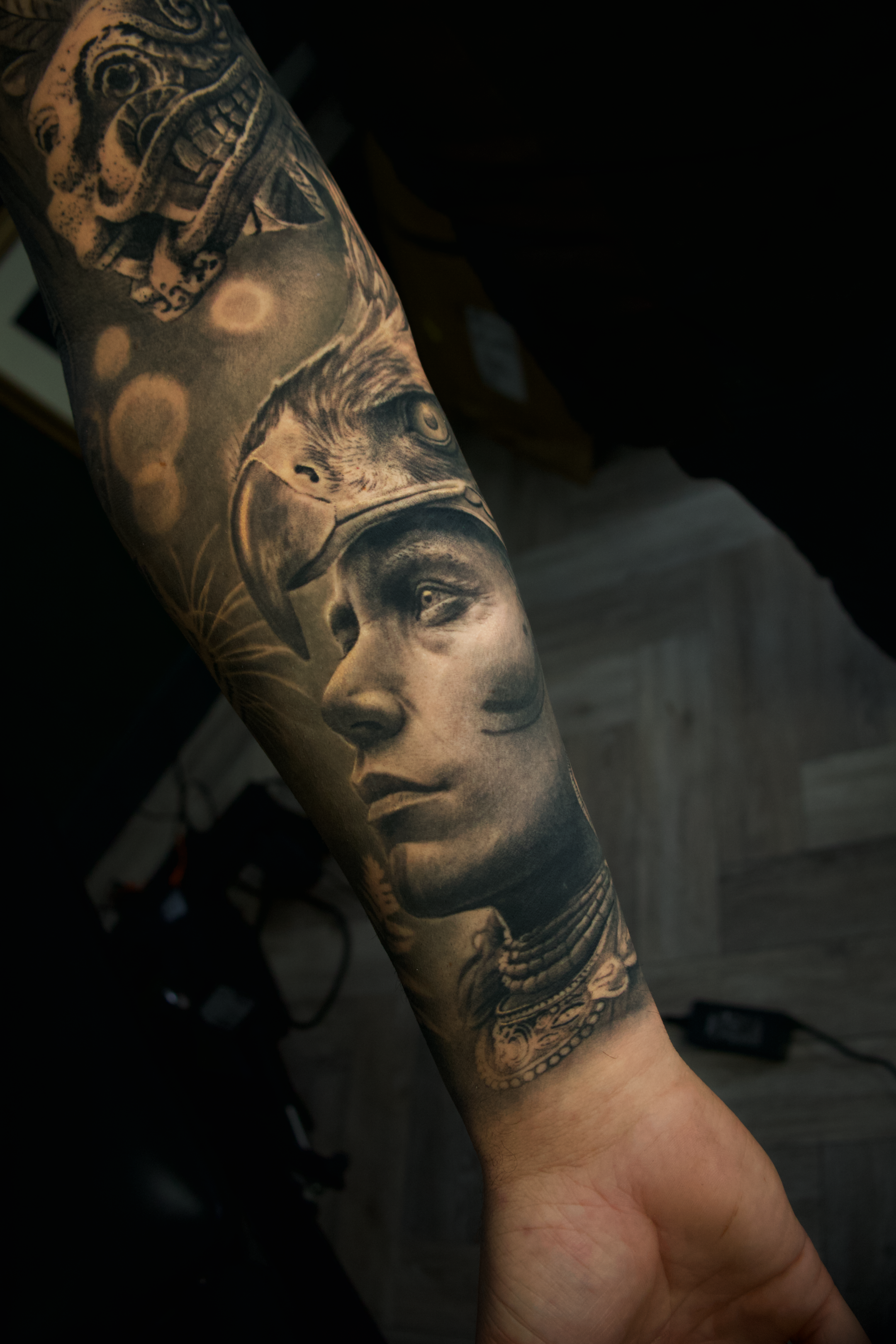 Tattoo sleeve featuring a woman's face, a wolf, and a tiger, with detailed shading and realistic style.