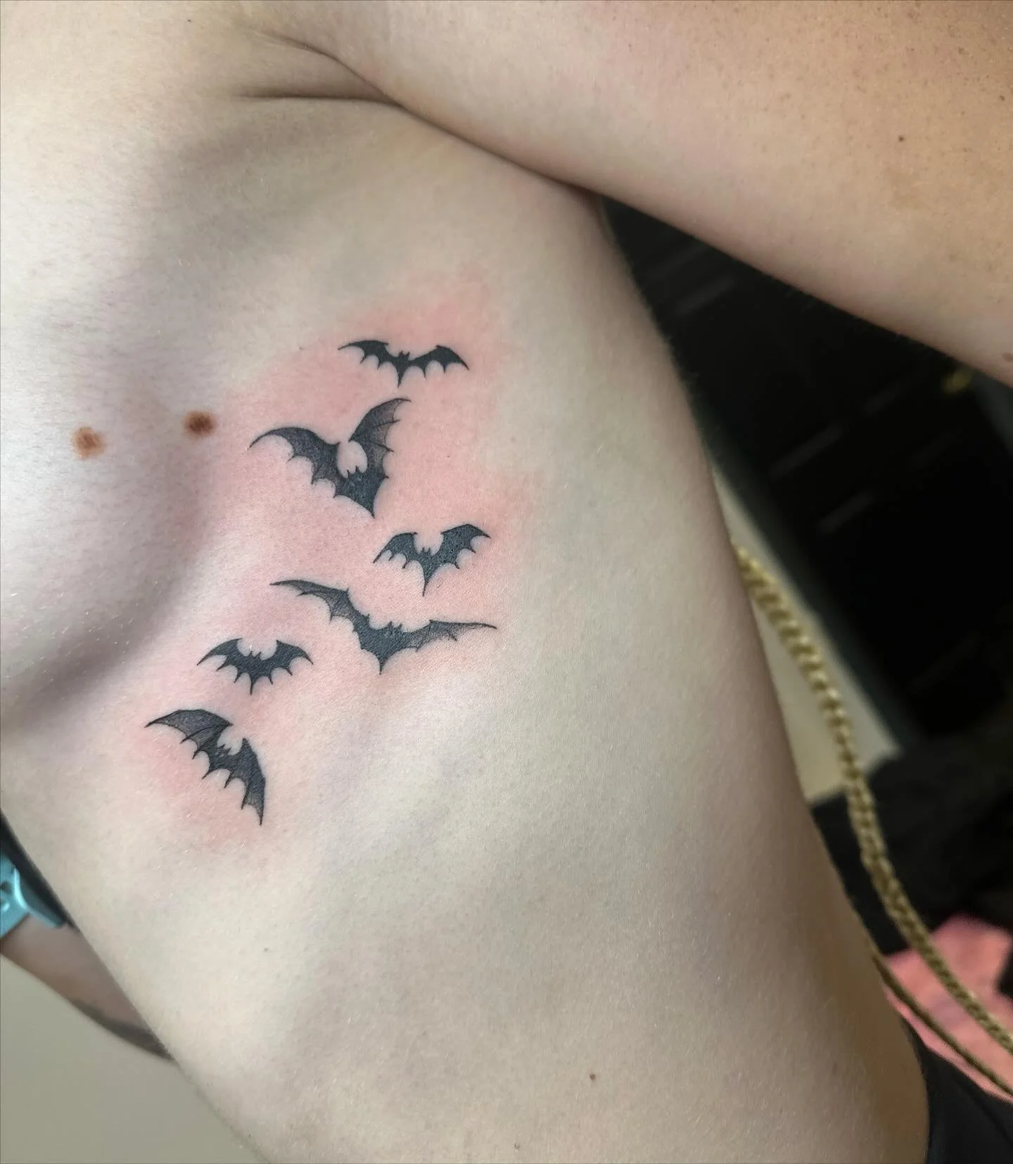 Spooky little bats! 🦇 #spookytattoo #halloweentattoo #battattoo #frickenbats #sideboobtattoo #ribtattoo #femaletattooer #femaletattooartist #womanownedbusiness #blackandgraytattoos