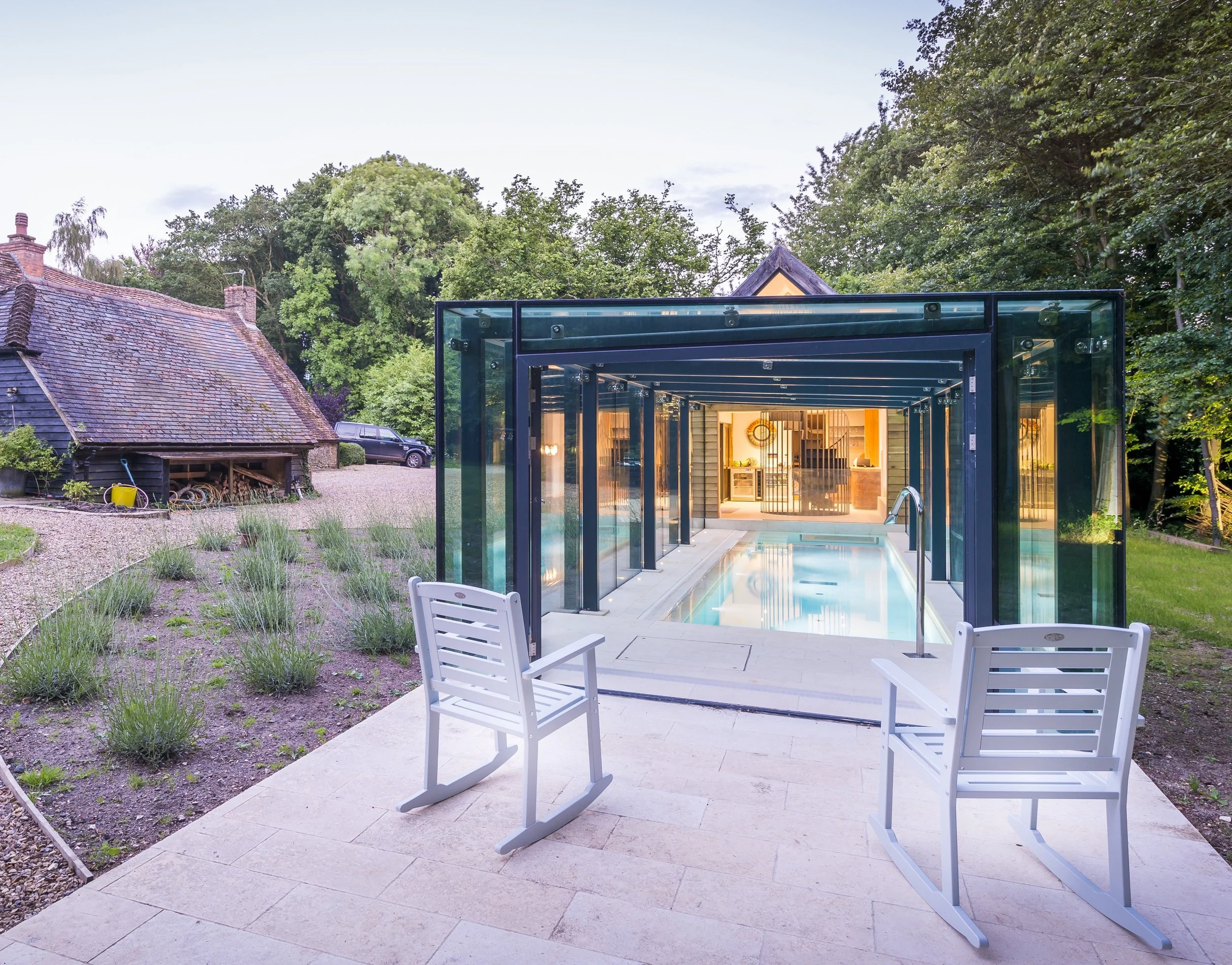 Modern glass house extension with an indoor swimming pool, demonstrating bold contemporary residential architecture that enhances everyday living.