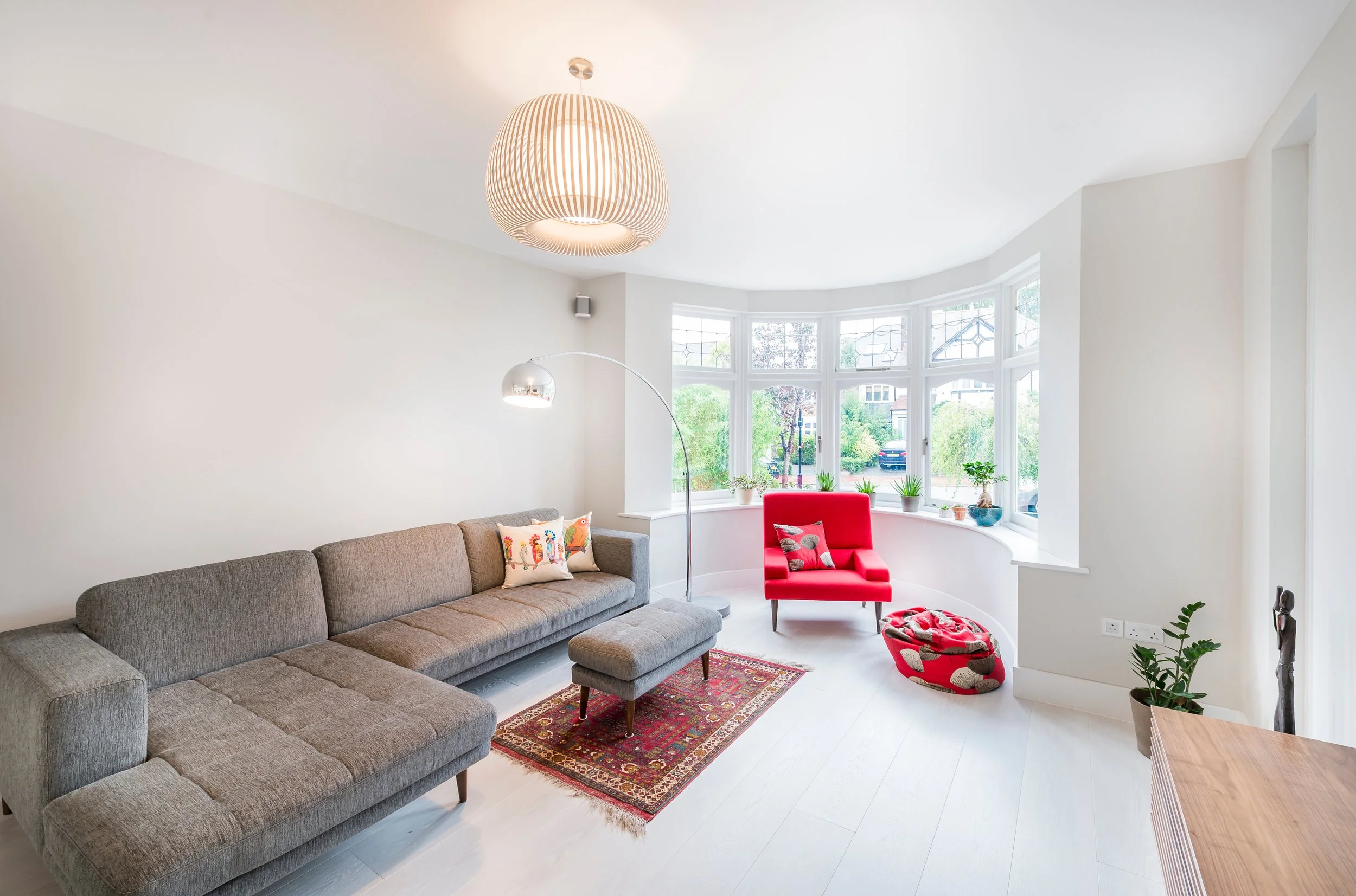 Contemporary living room with bespoke interior design, bay window, feature lighting and modern furnishings.