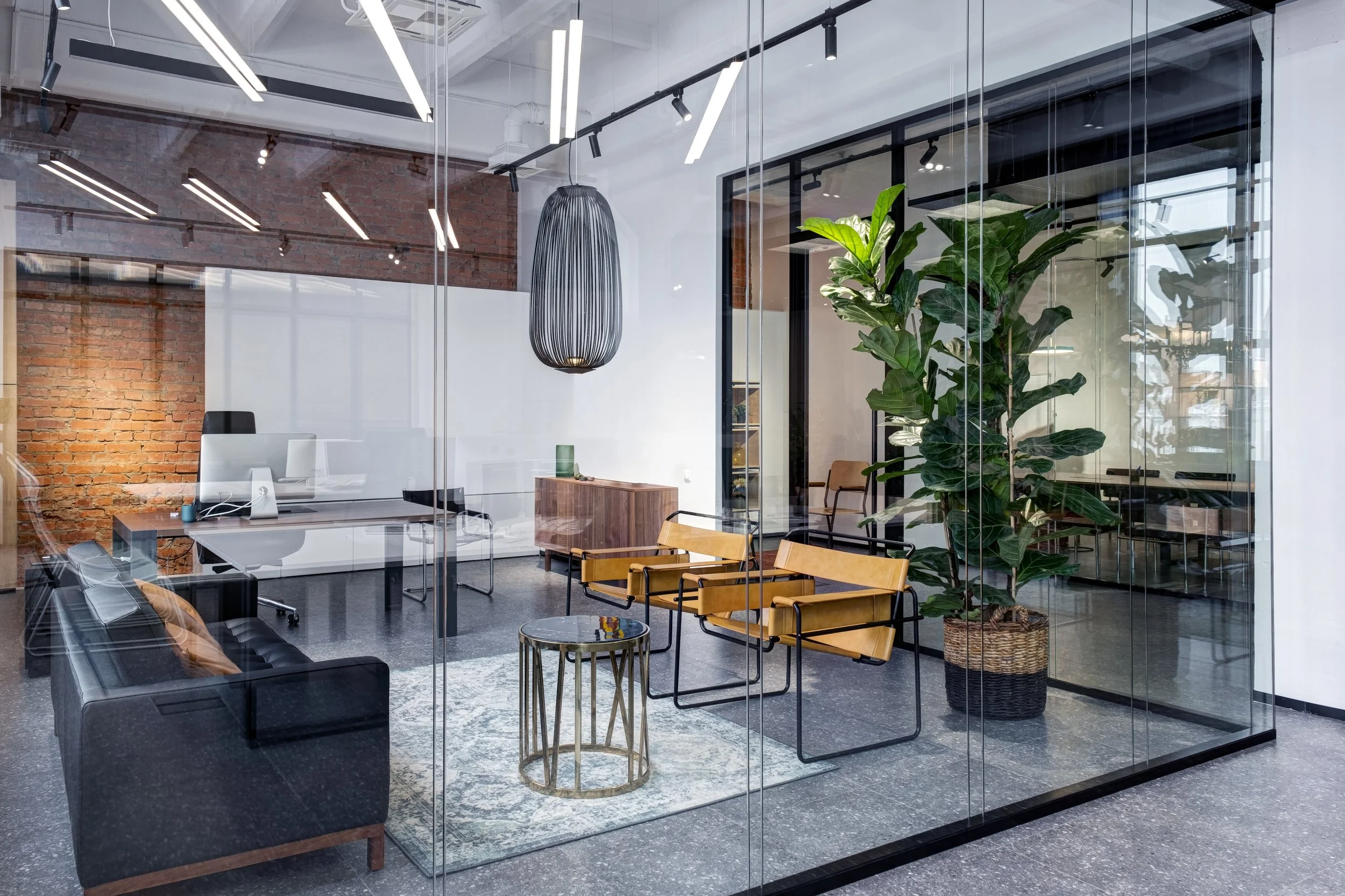 Contemporary commercial office interior showcasing modern workspace design, glass partitions, exposed brickwork and premium finishes.