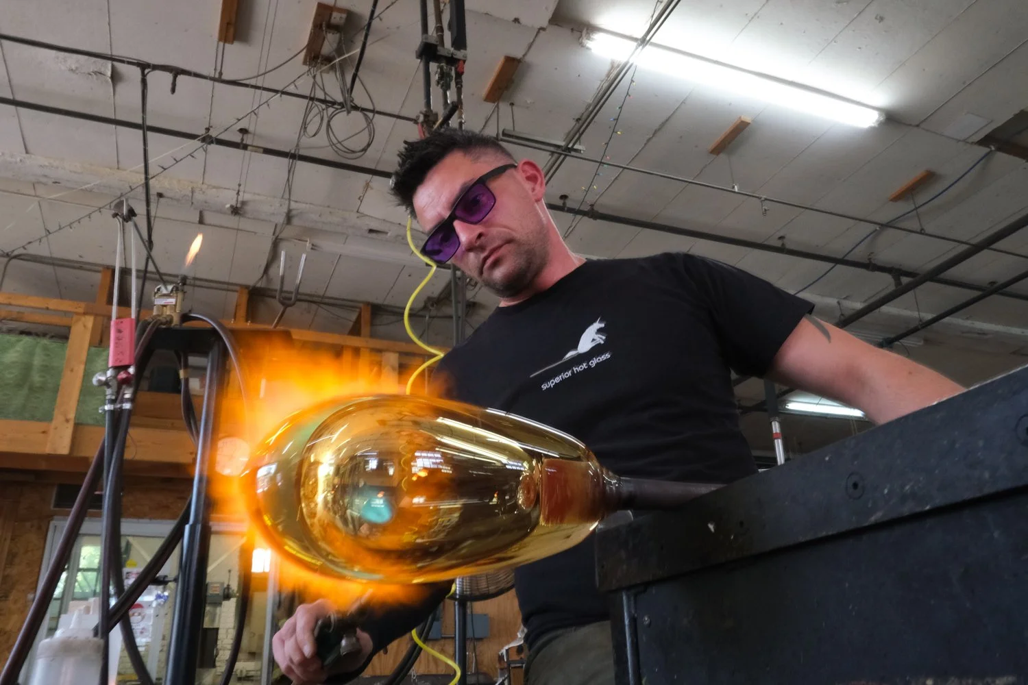 Photo of Zac Gorell blowing glass. Photo taken by Laura Wimbels