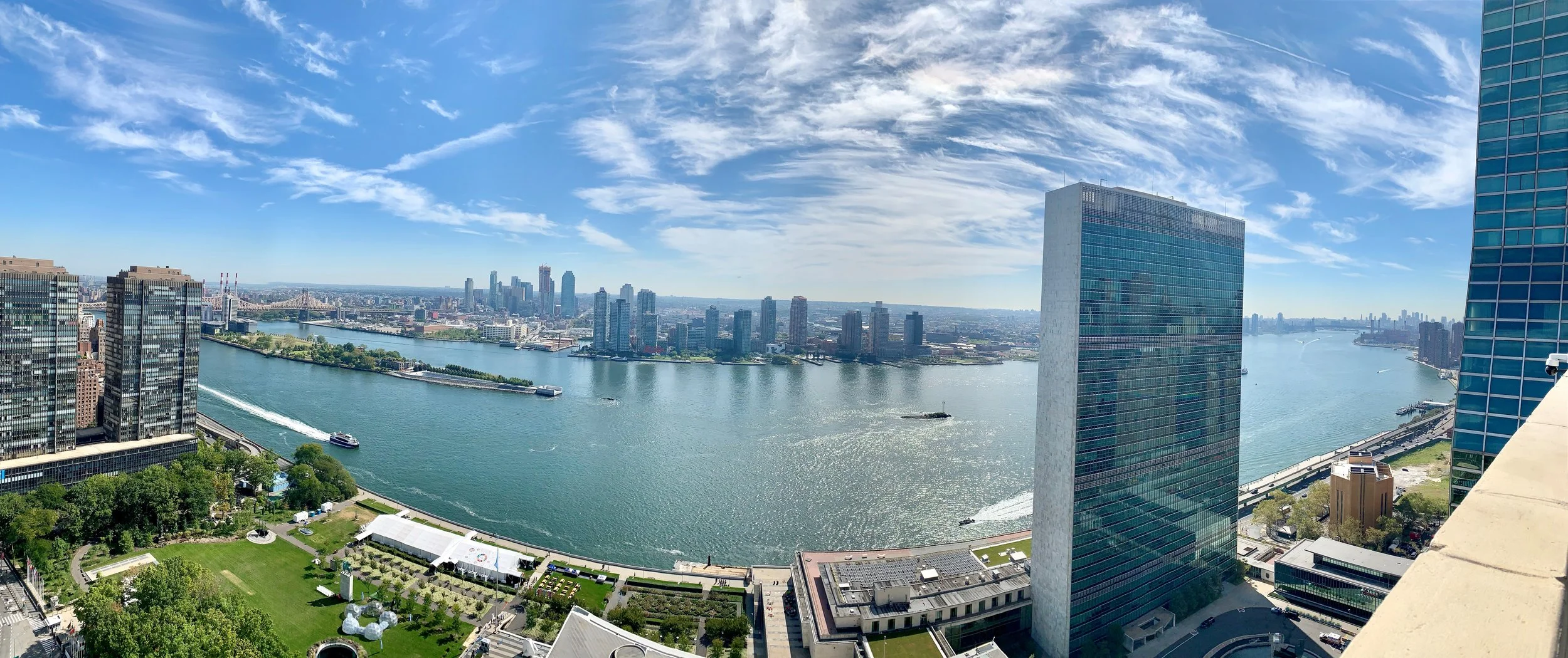 Archival panoramic view of the United Nations Secretariat building beside New York’s East River under a blue sky, September 2019.