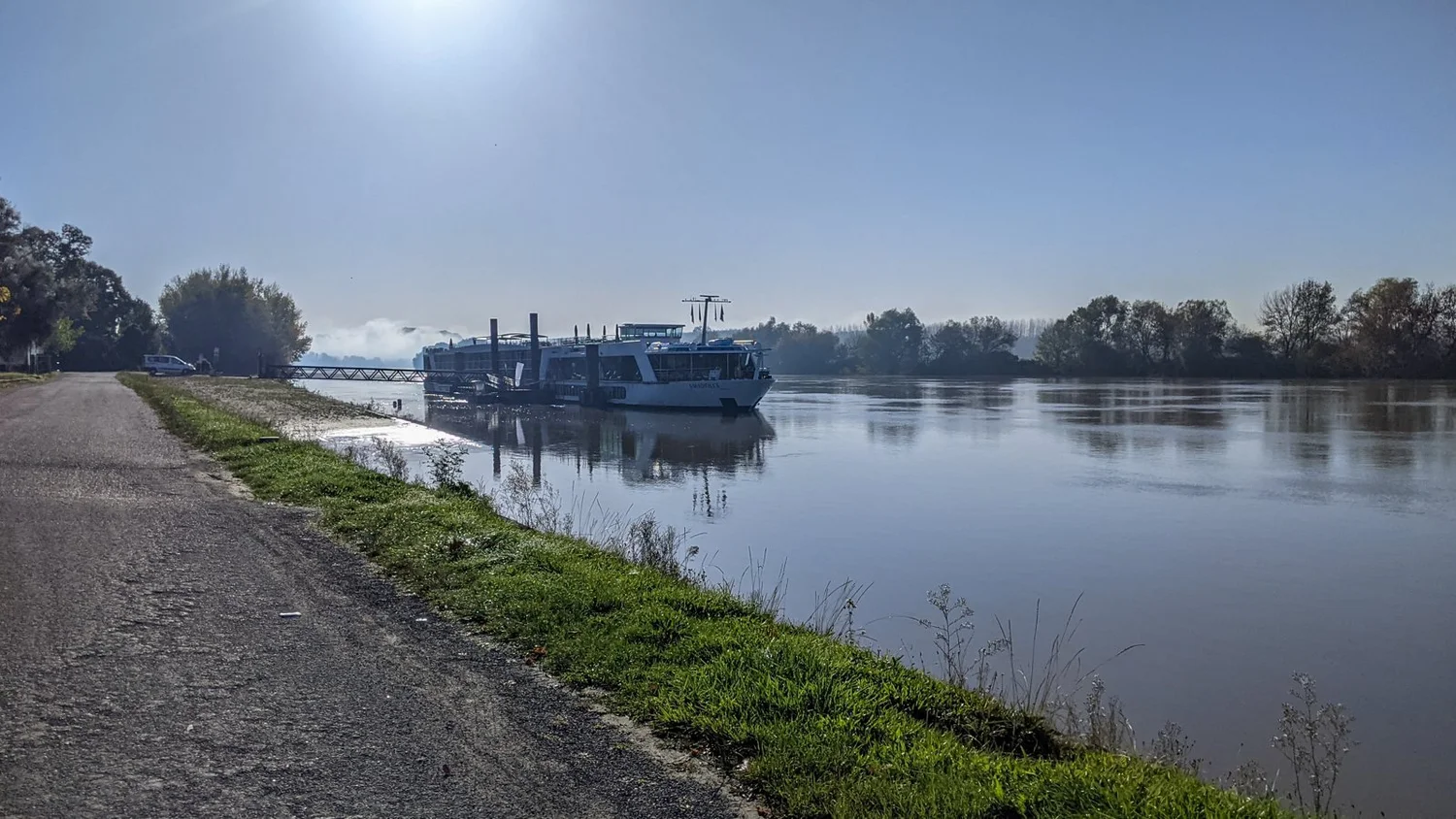 A river cruise ship moored on a calm river on an early autumn morning