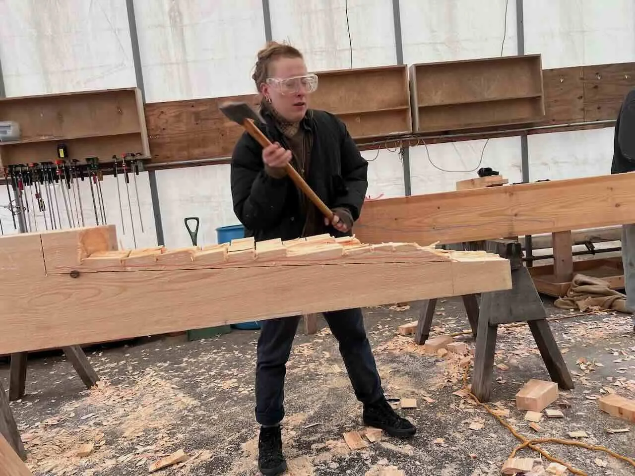 Workshop participant chops scarf joint with axe