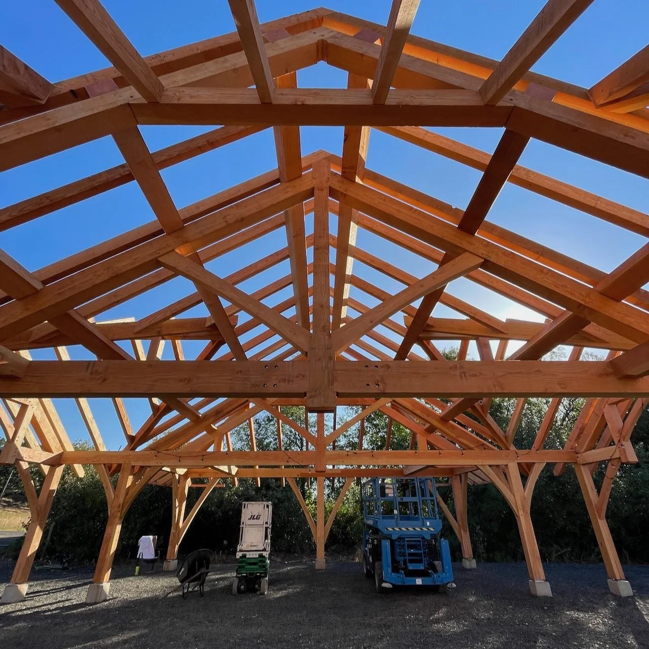 Heavy timber king post truss in sunny pavilion
