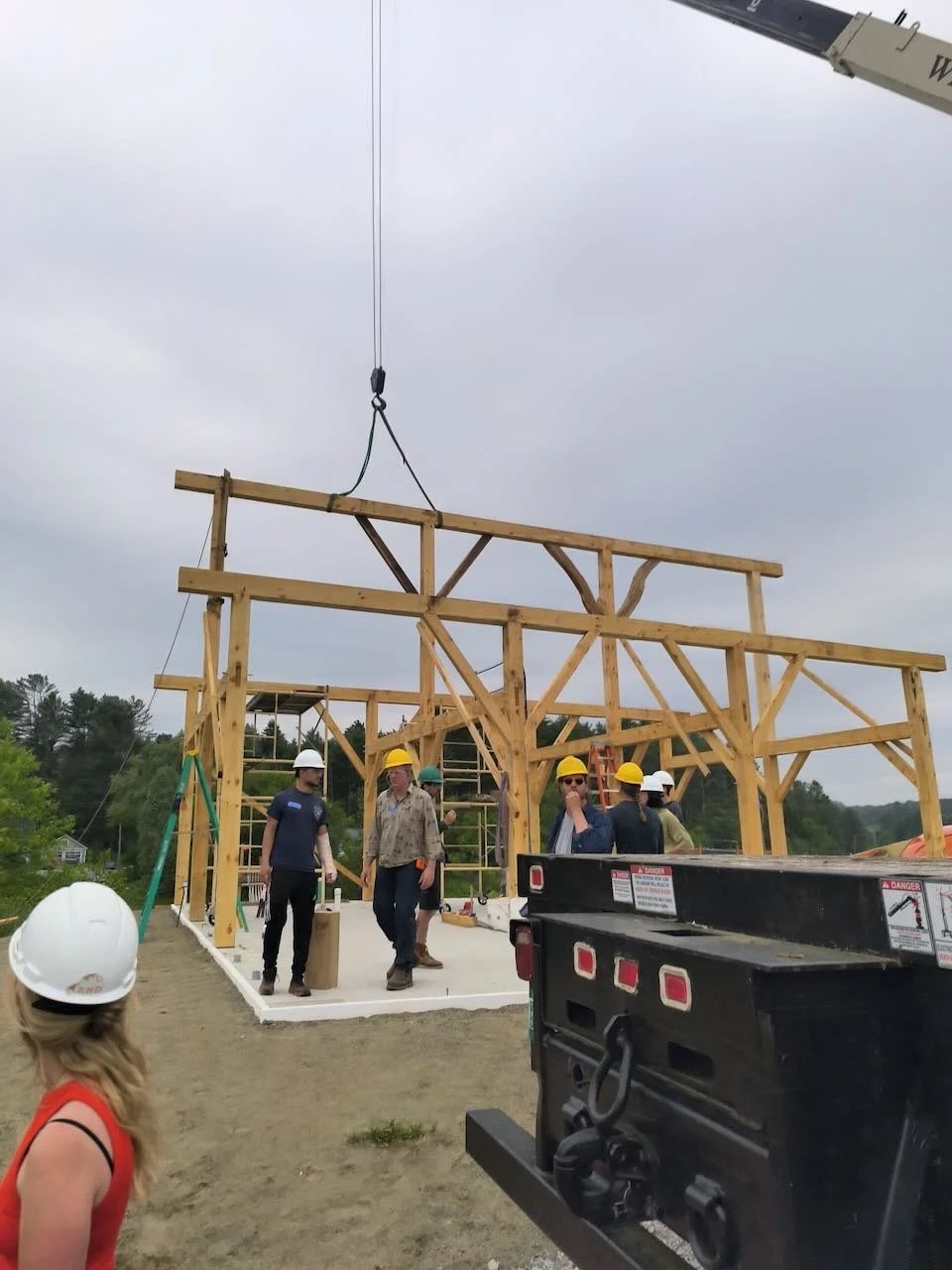 Crane lifts timber ridge beam into position
