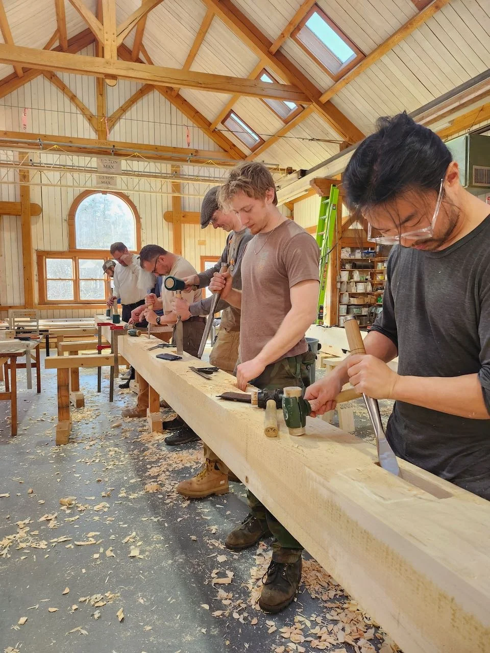 Timber frame students cutting mortises