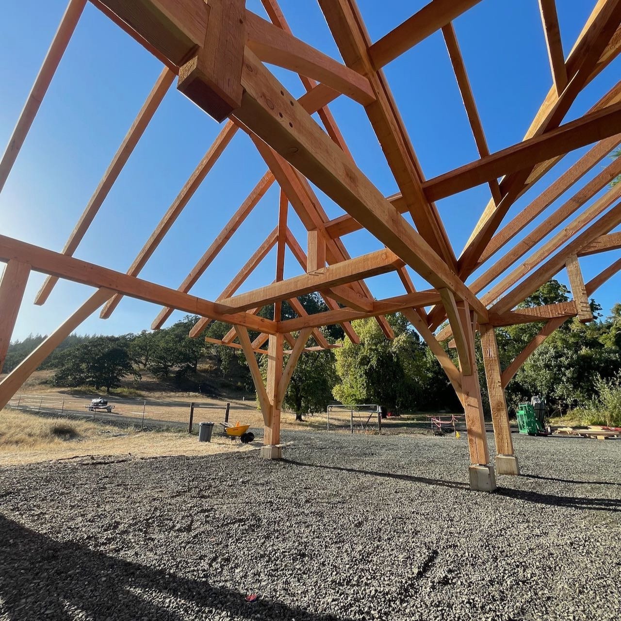 Sunny sky behind newly raised timber frame rafters