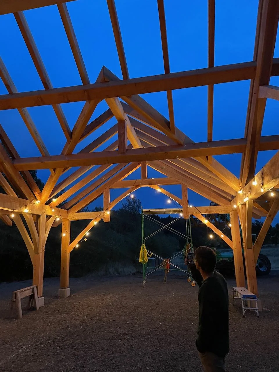 Newly raised timber frame pavilion lit up at night