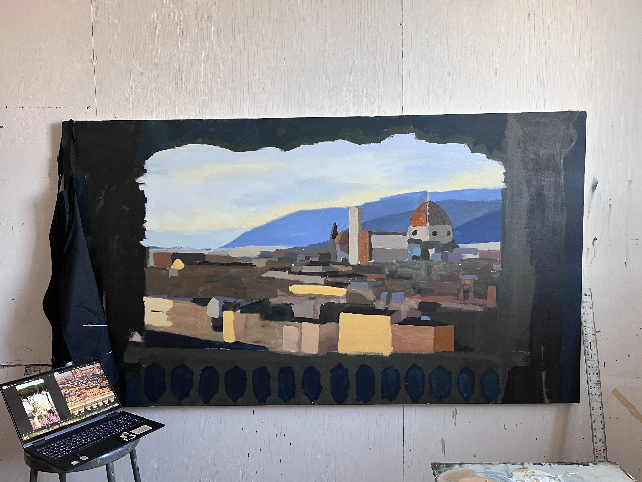Large canvas painting created by artist Metzli Flores also known as fartingsky. The painting is of a view of Florence Italy through a balcony view. Her laptop is propped next to the laptop.