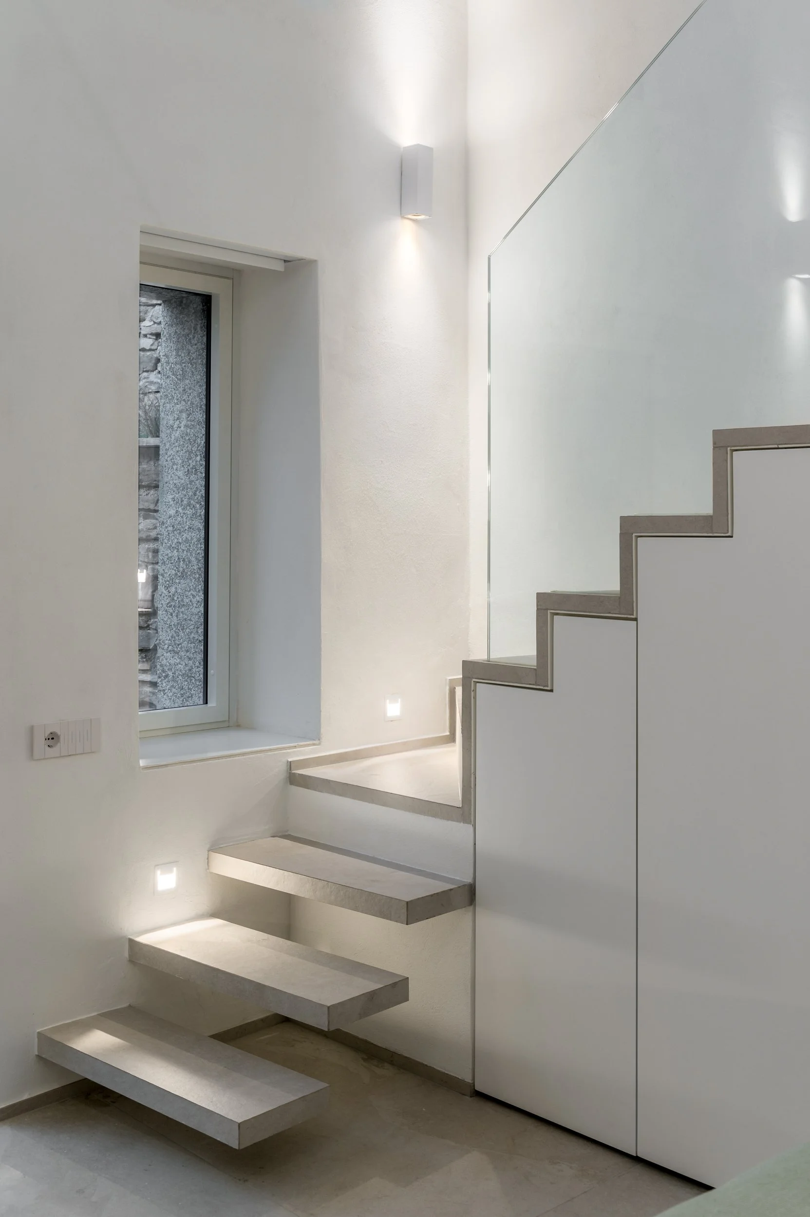 Scala sospesa minimalista con illuminazione integrata e armadio sottoscala.