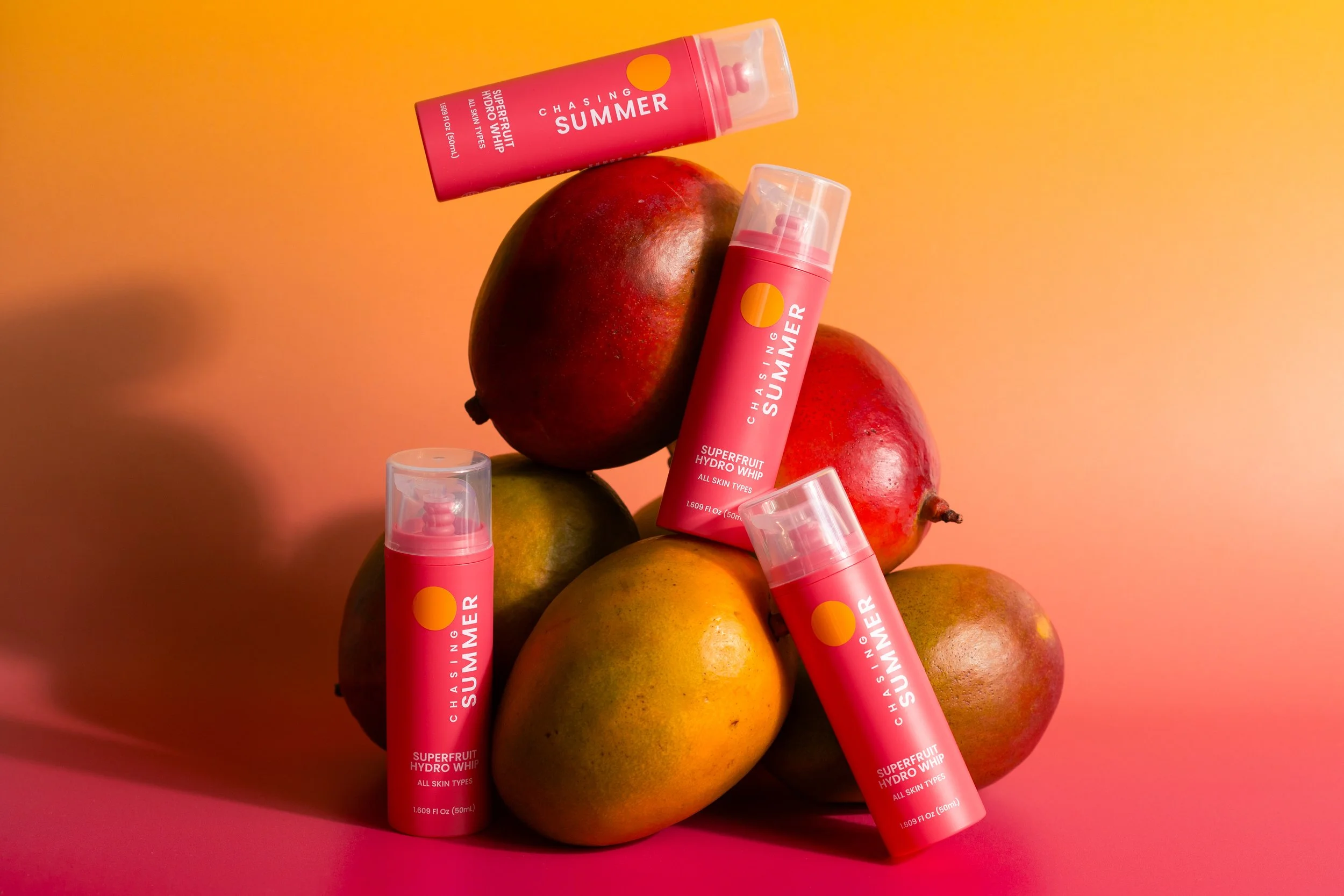 Gentle superfruit skincare for teens, shown with bottles among ripe mangoes