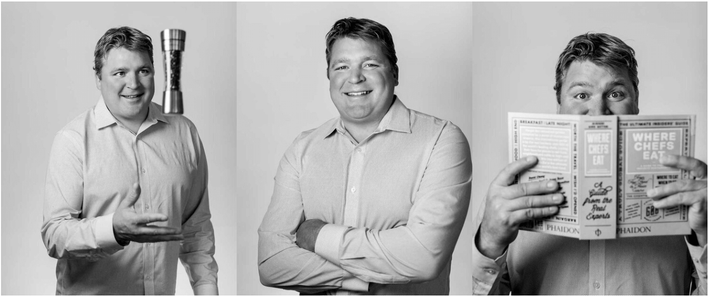 Three men in dress shirts posing for a photo. The man on the left is holding a trophy, the man in the middle is smiling with his arms crossed, and the man on the right is holding and reading a cookbook titled 'Where Chefs Eat'.