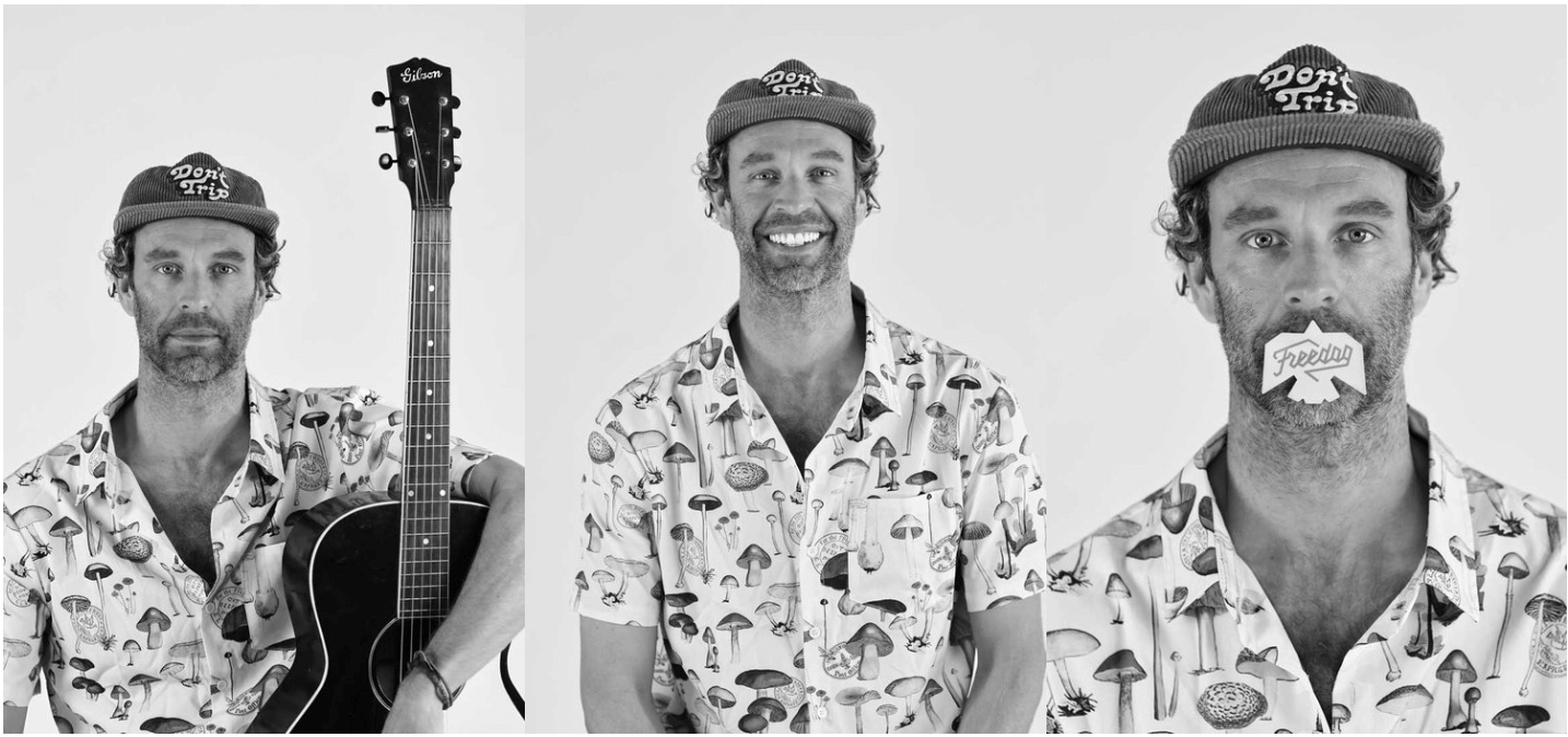 Three men wearing matching mushroom-patterned shirts, with the man on the left holding an acoustic guitar and wearing a beanie that says 'Dept of Tries.' The man in the middle has a big smile, and the man on the right has tissue paper with the words 'Freedom' taped over his mouth.