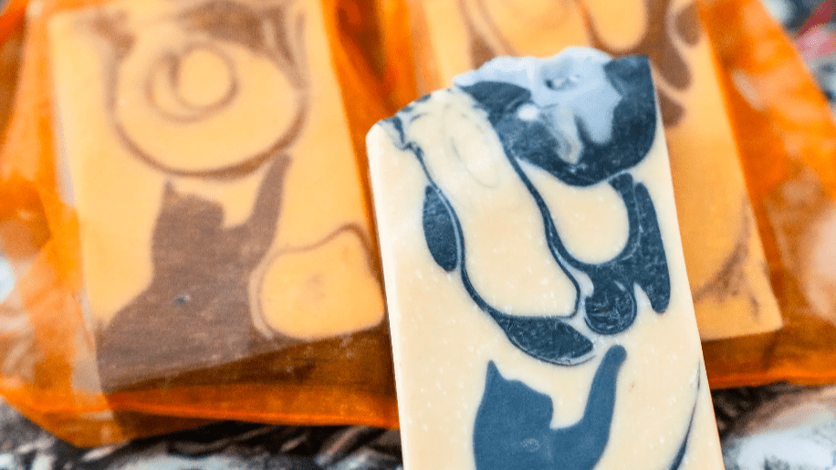 Close-up of a white and dark chocolate bar with marble swirl pattern, partially wrapped in orange packaging.