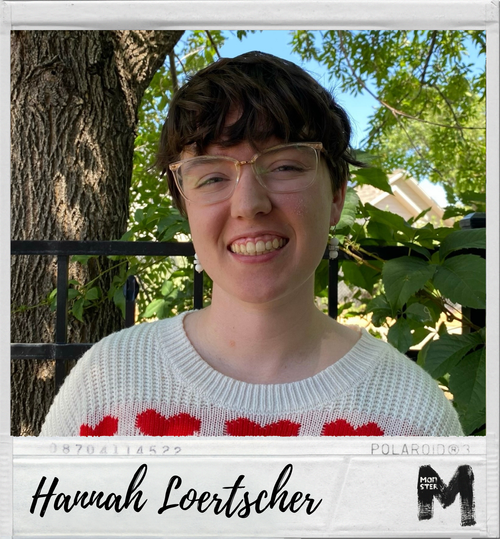 A young person with short dark hair, wearing glasses, smiling, standing outdoors in front of a tree and green foliage, wearing a white sweater with red hearts, and a Polaroid-style border with the name Hannah Loertscher written on it.