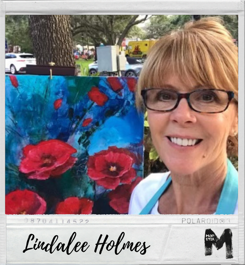 Woman with short red hair and glasses smiling next to a colorful painting of red flowers.