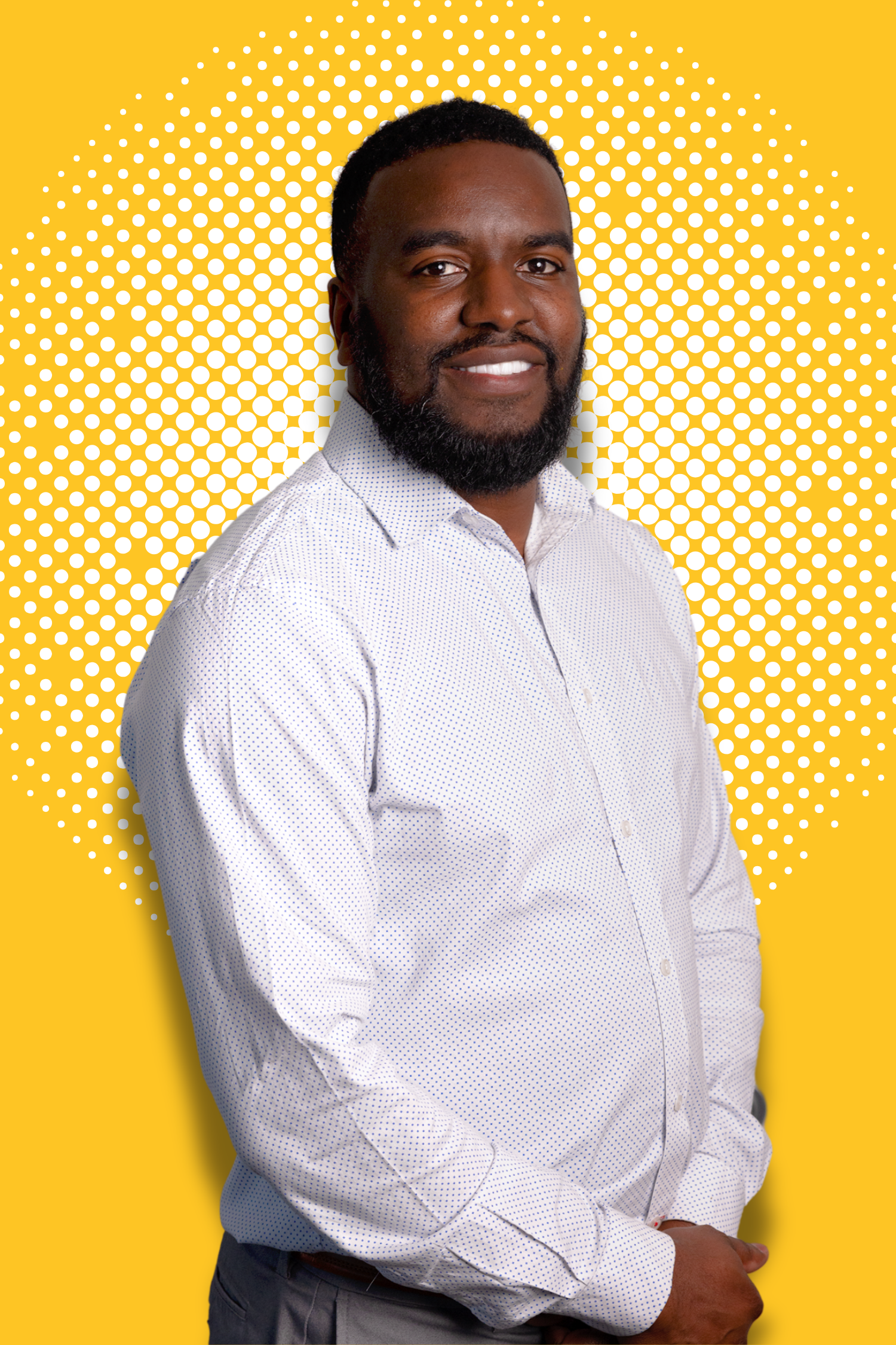 Man smiling in a white dress shirt in front of a yellow and white dotted background.