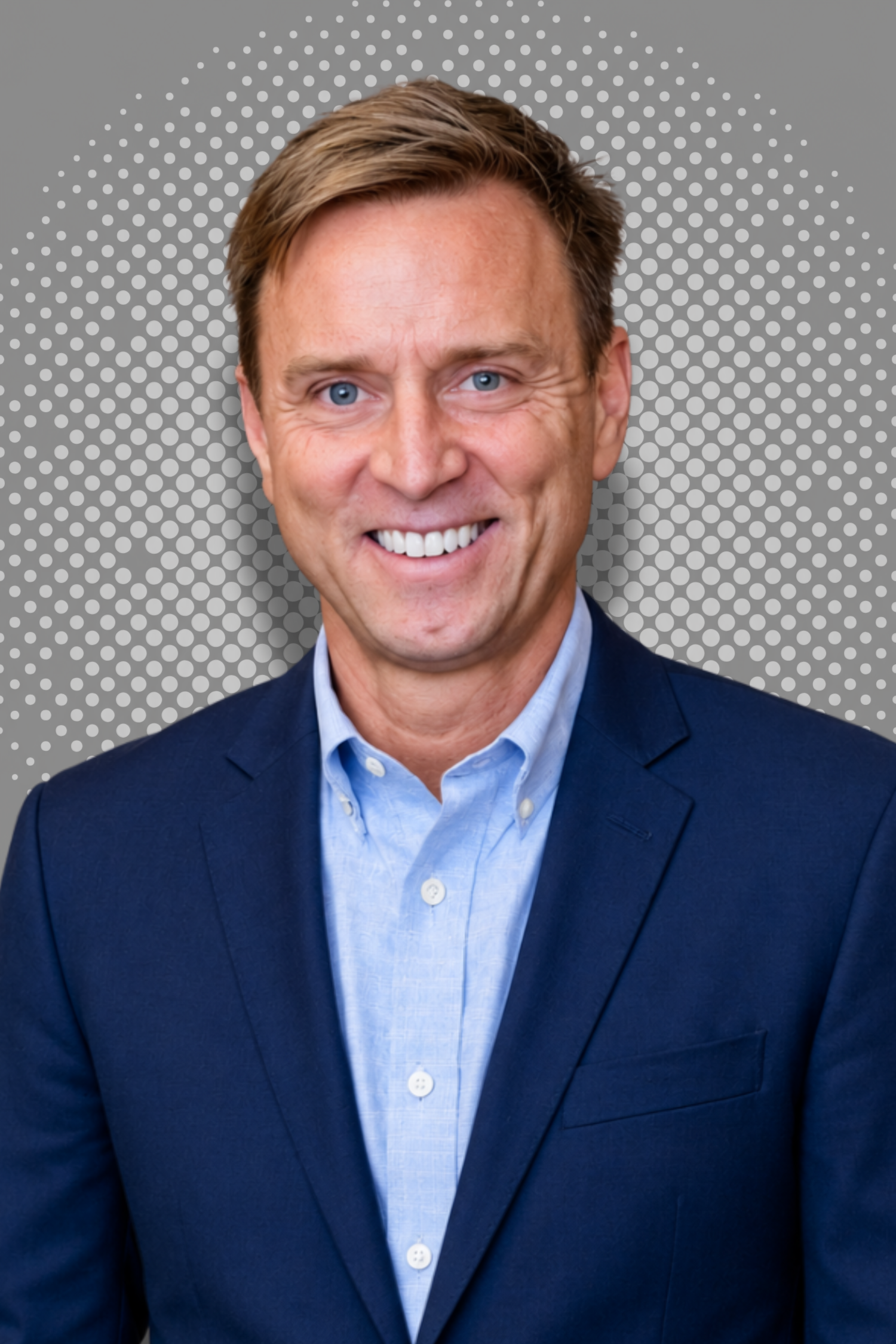 Smiling man in a suit with a polka dot background.