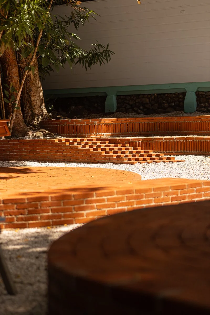 Outdoor brick steps with trees and a building in the background.