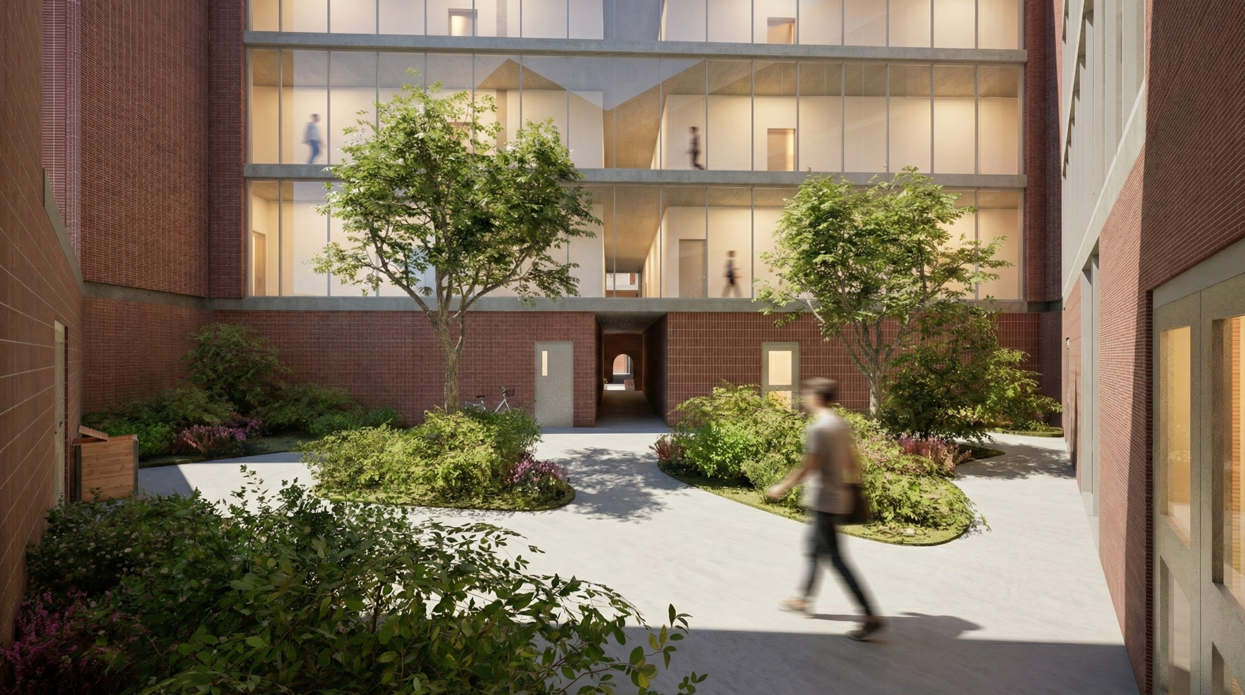 A courtyard with trees, plants, and walking paths surrounded by modern brick buildings with large glass windows. Several people are walking, and a person is seen riding a bicycle.