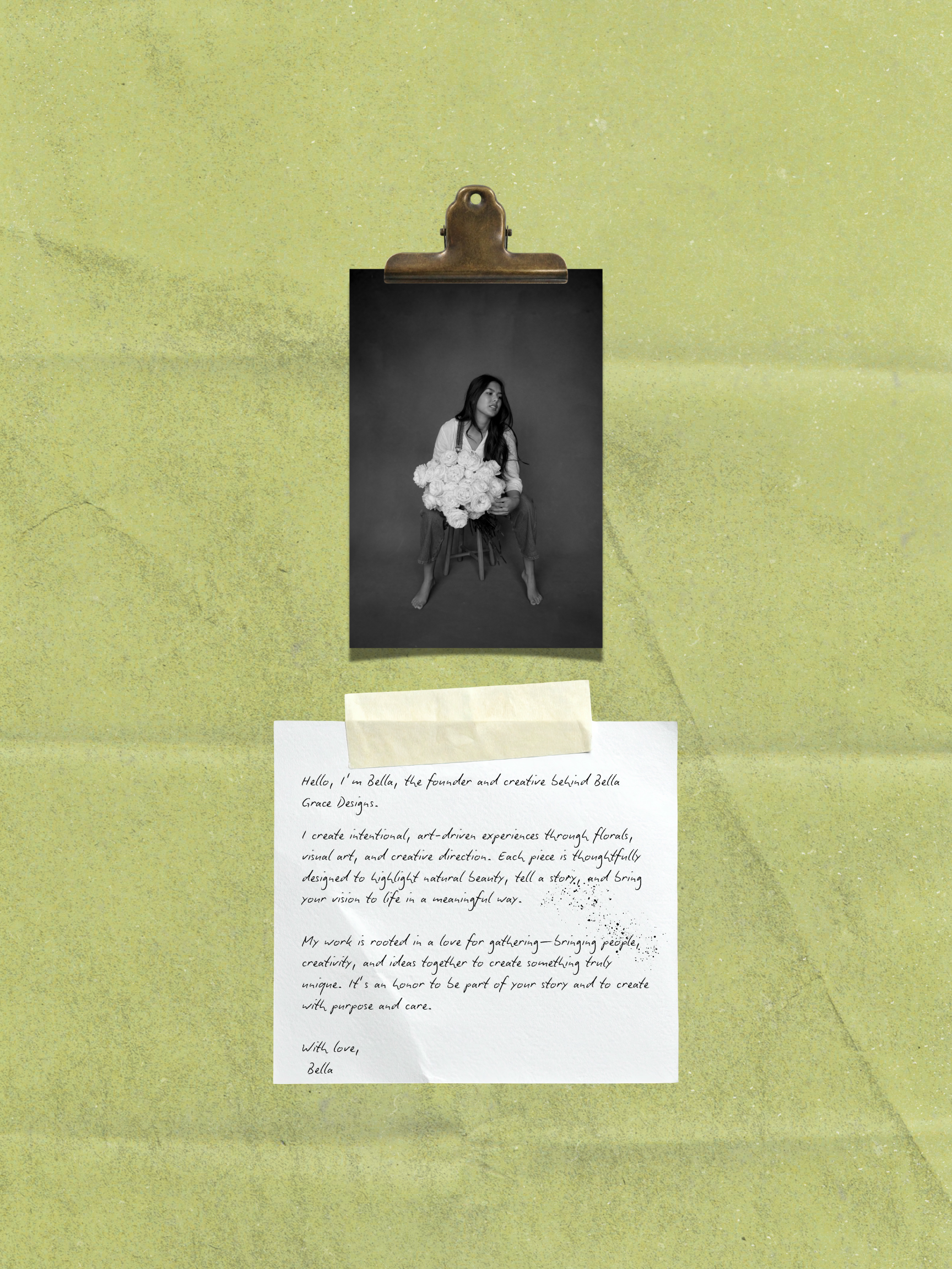 A black-and-white photograph of a woman sitting on a stool holding a bouquet of flowers, with handwritten text on a white sheet of paper below the photo. The background is neutral gray.