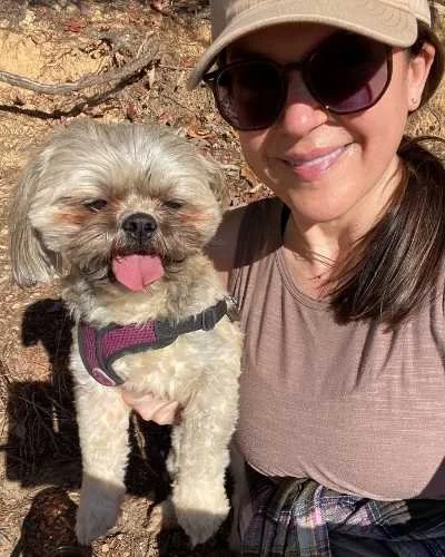 Melissa Rolfes smiling outdoors with her dog